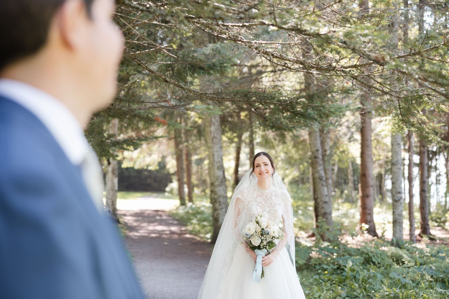 Série photo de mariage montrant un couple en bleu marine et blanc en extérieur, avec un bouquet floral blanc délicat.