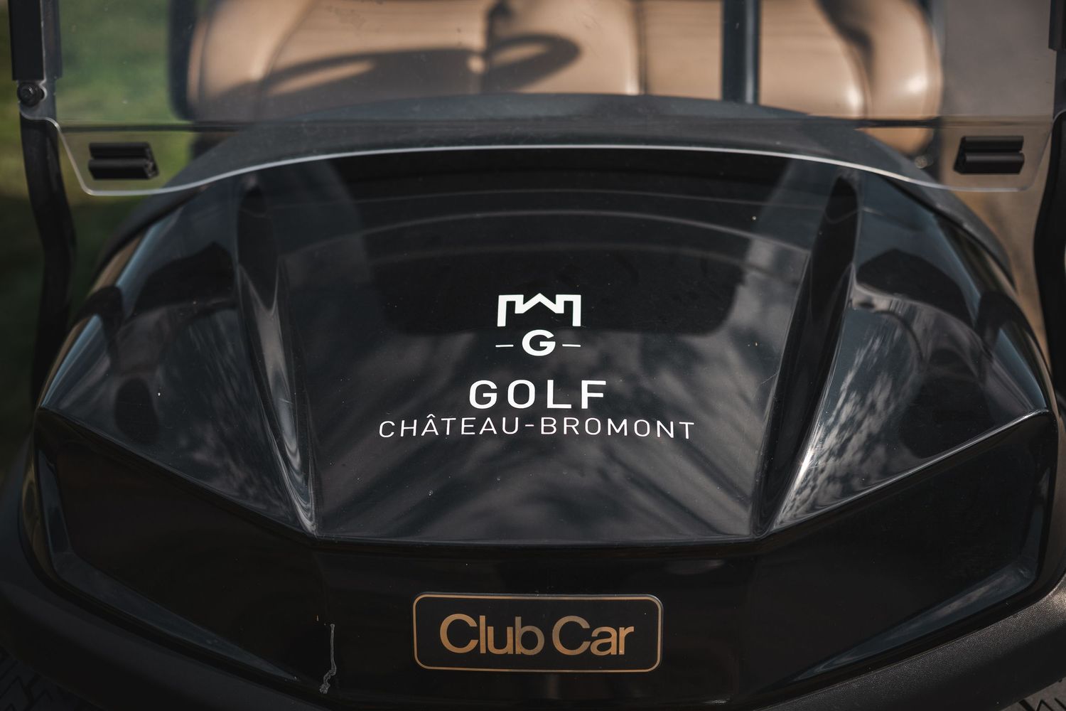 Close-up of a black Club Car golf cart with Chateau Beaumont logo at a luxury resort.