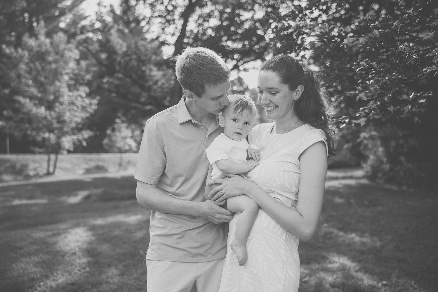 hotographie de famille en plein air, rires et jeux sous le soleil avec arbres en arrière-plan, pour valoriser lien et joie partagée
