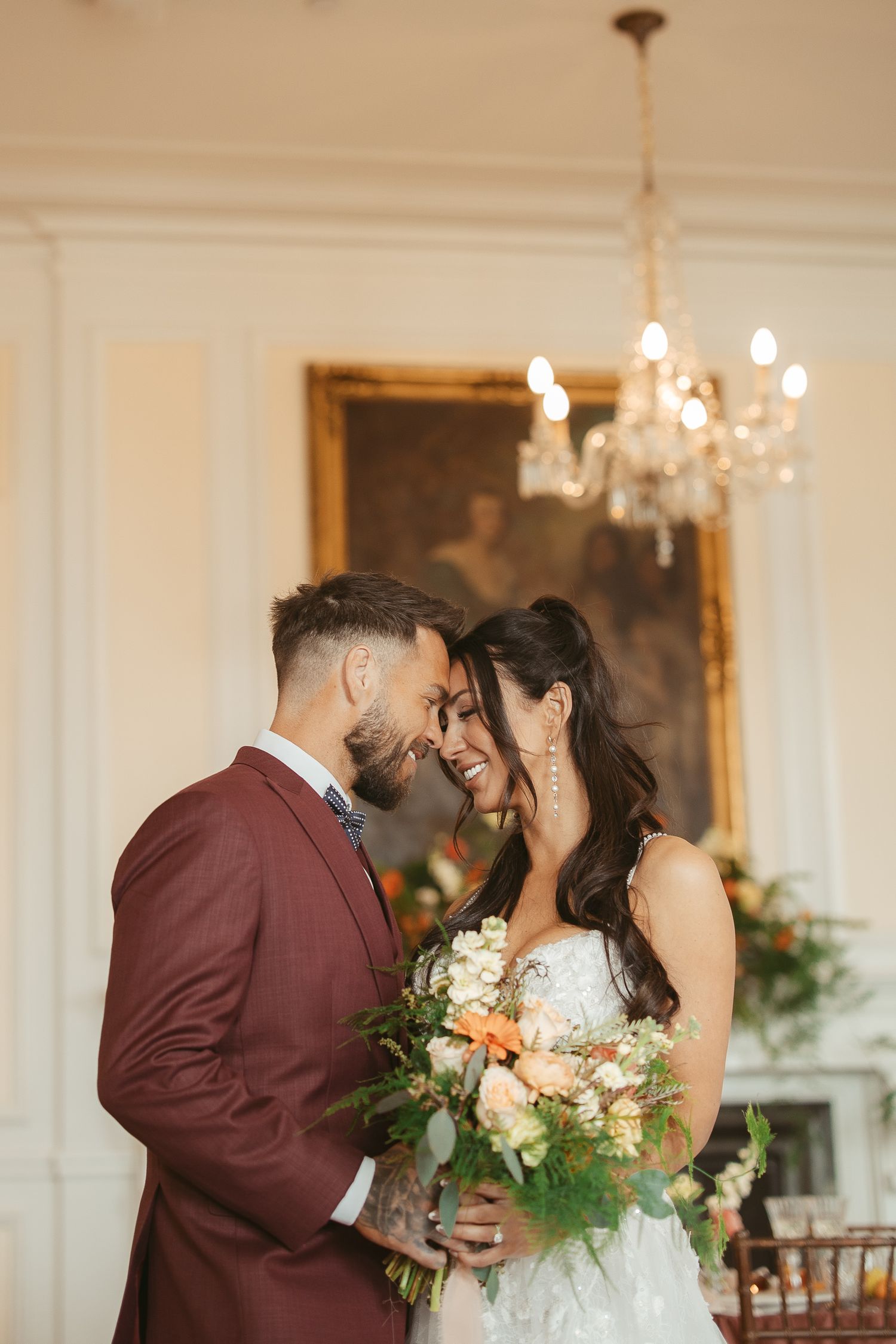 Romantic wedding couple sharing a tender moment during their first dance under elegant crystal chandeliers.