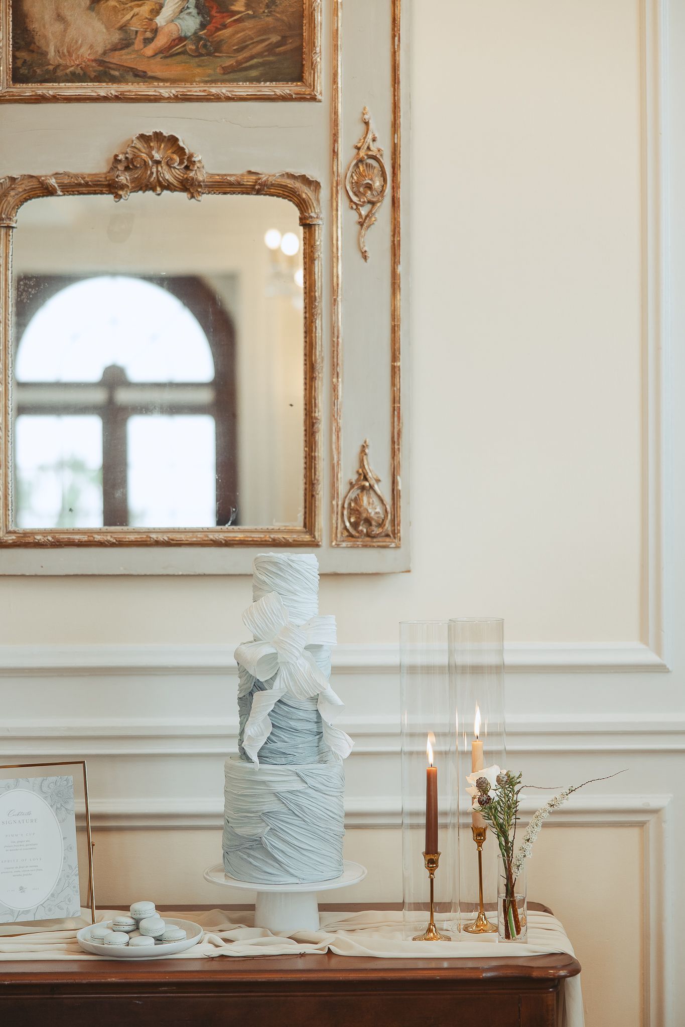 Table de réception de mariage élégante avec gâteaux étagés bleu pâle et miroirs dorés au Manoir Richelieu à Charlevoix
