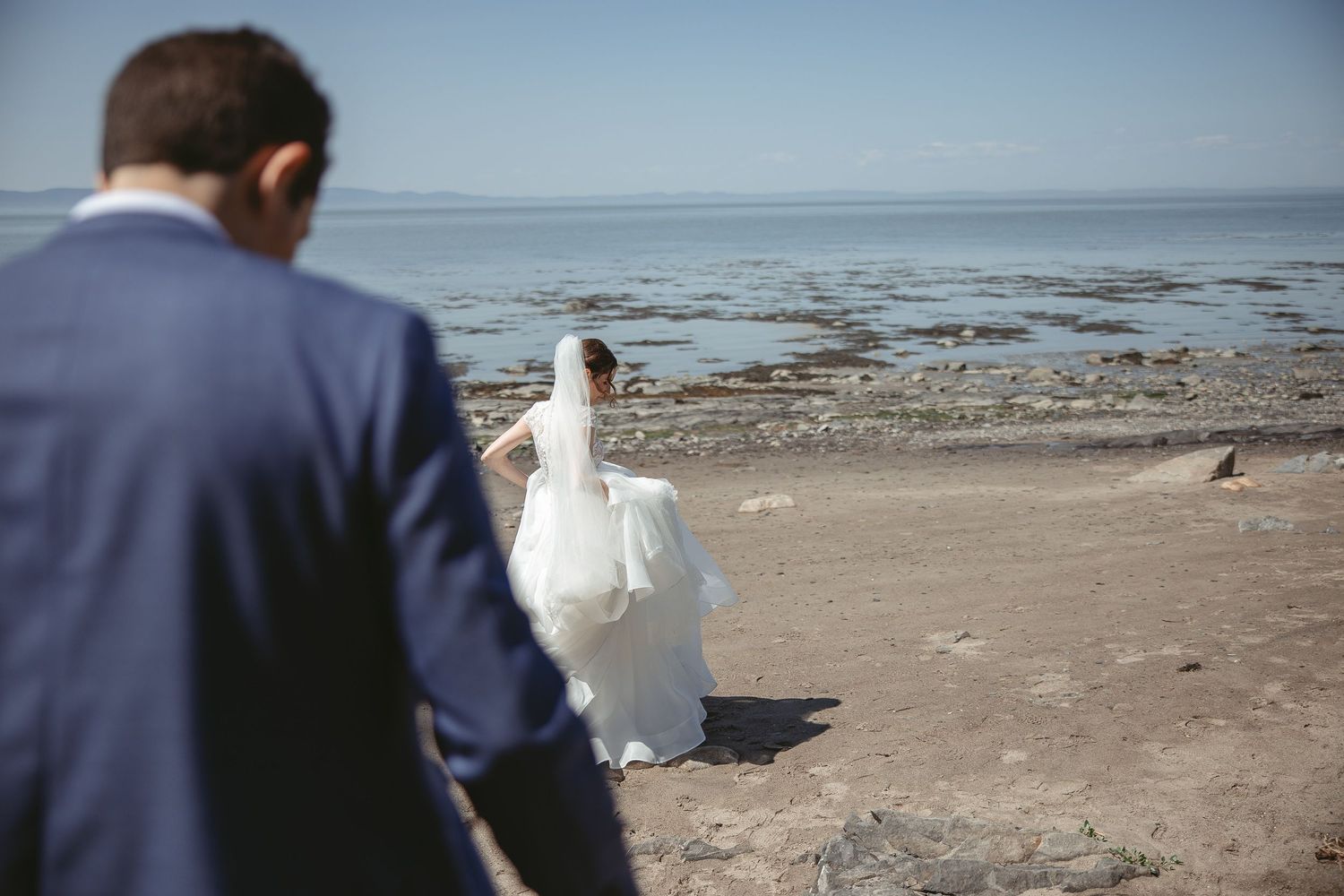 un couple de mariés qui marche sur le bord du fleuve à Rivière-du-Loup