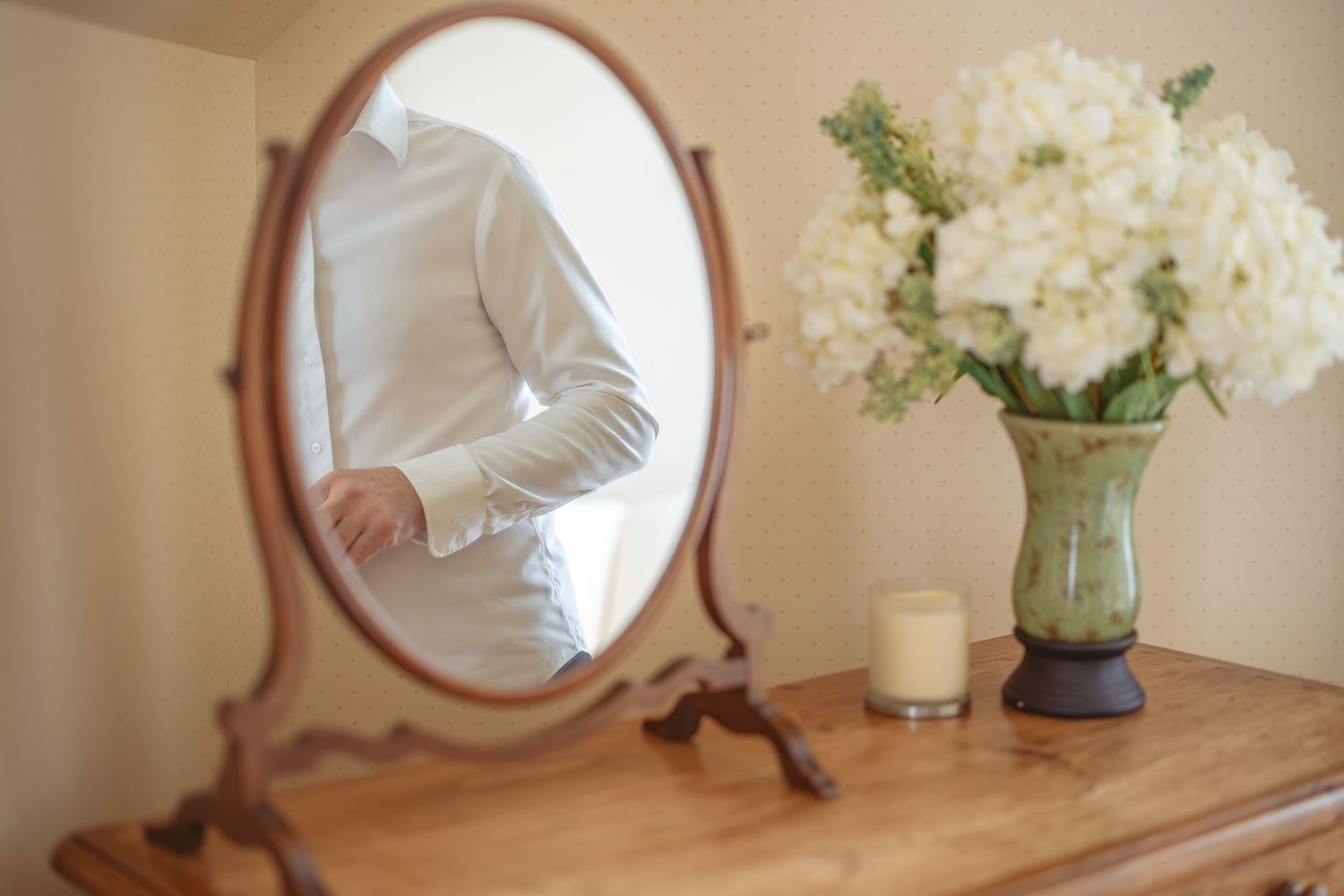 Elegant interior with antique mirror and white floral arrangements.