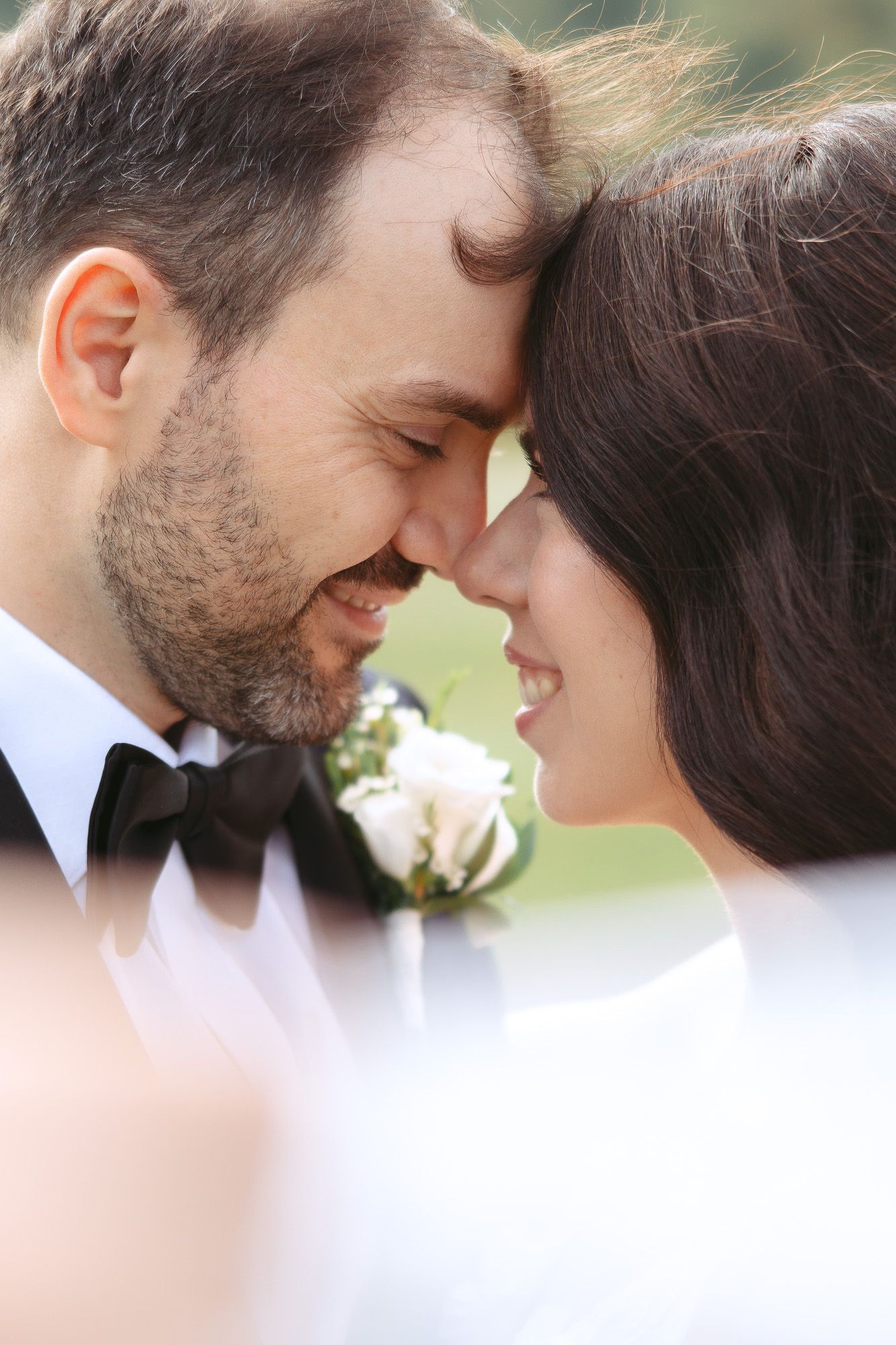 Moment intime en gros plan de jeunes mariés front contre front, en lumière naturelle douce, mariage en Estrie