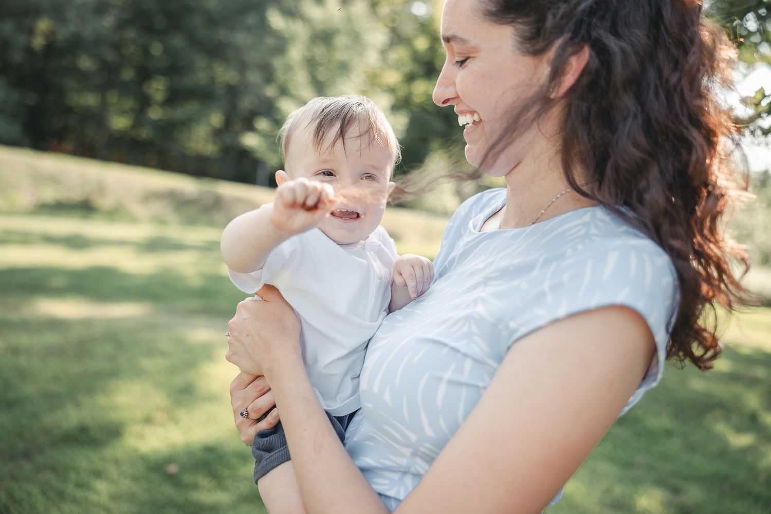 Parent et bébé partagent des moments tendres en extérieur, capturés en série de photos candides lors de l’heure doré
