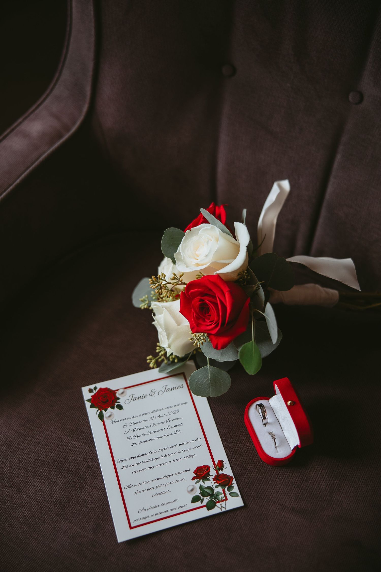 Wedding invitation cards with red and white roses on dark background create an elegant composition.
