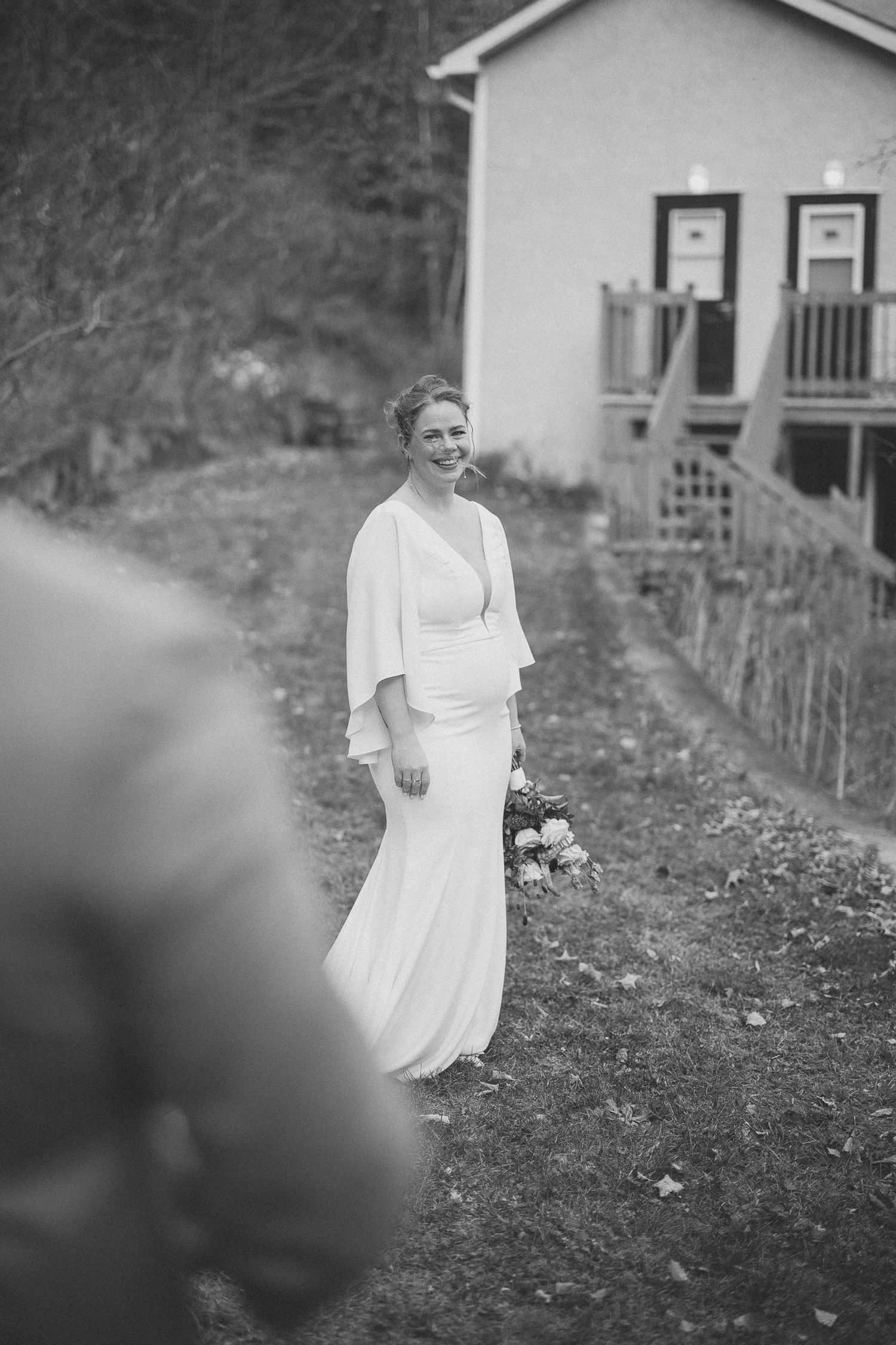 Noir et blanc la marié heureuse bouquet à la main regardant son mari
