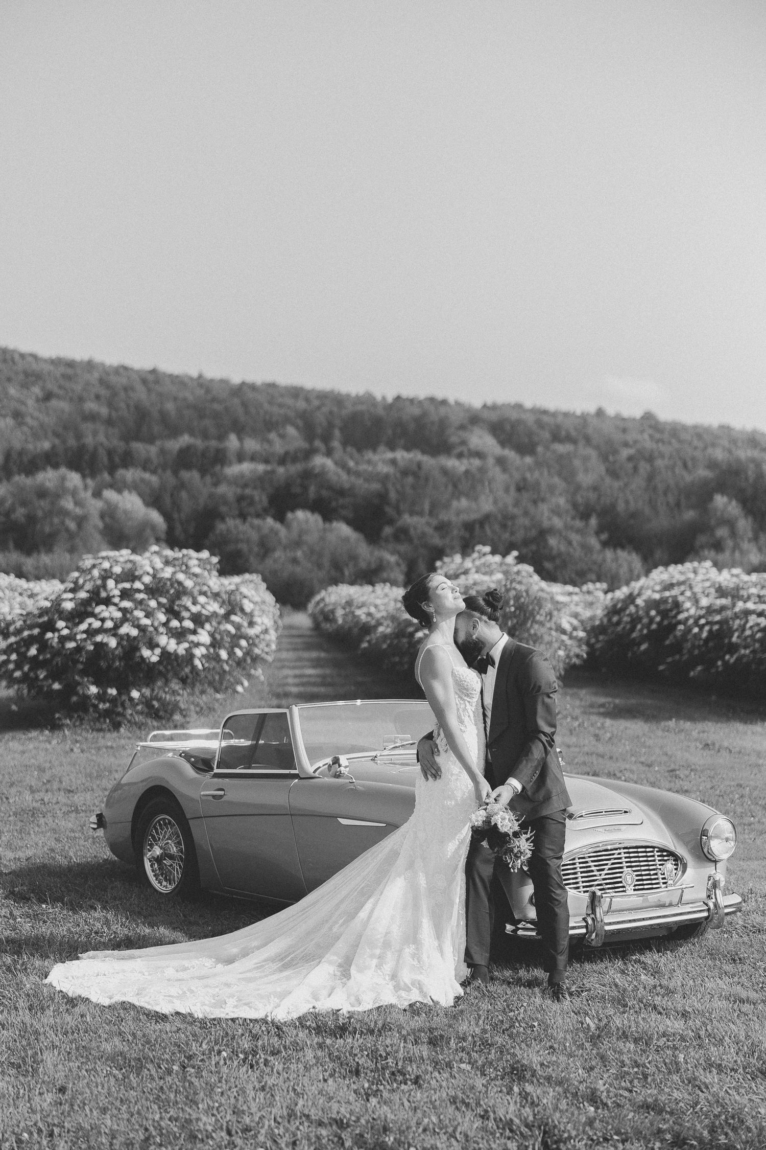 Noir et blanc couple qui s'embrasse avec voiture décapotable ancienne Austin