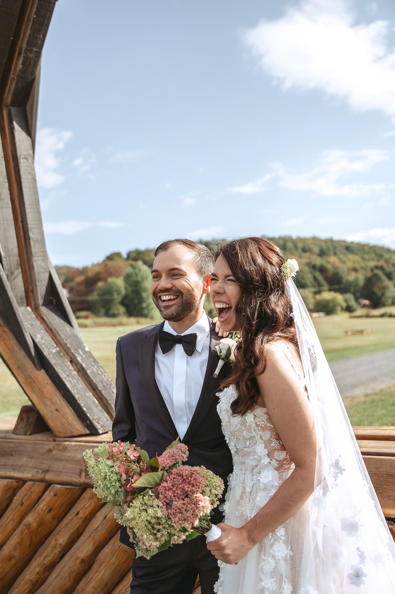 Éclat de rire spontané d’un couple lors d’un mariage en extérieur
