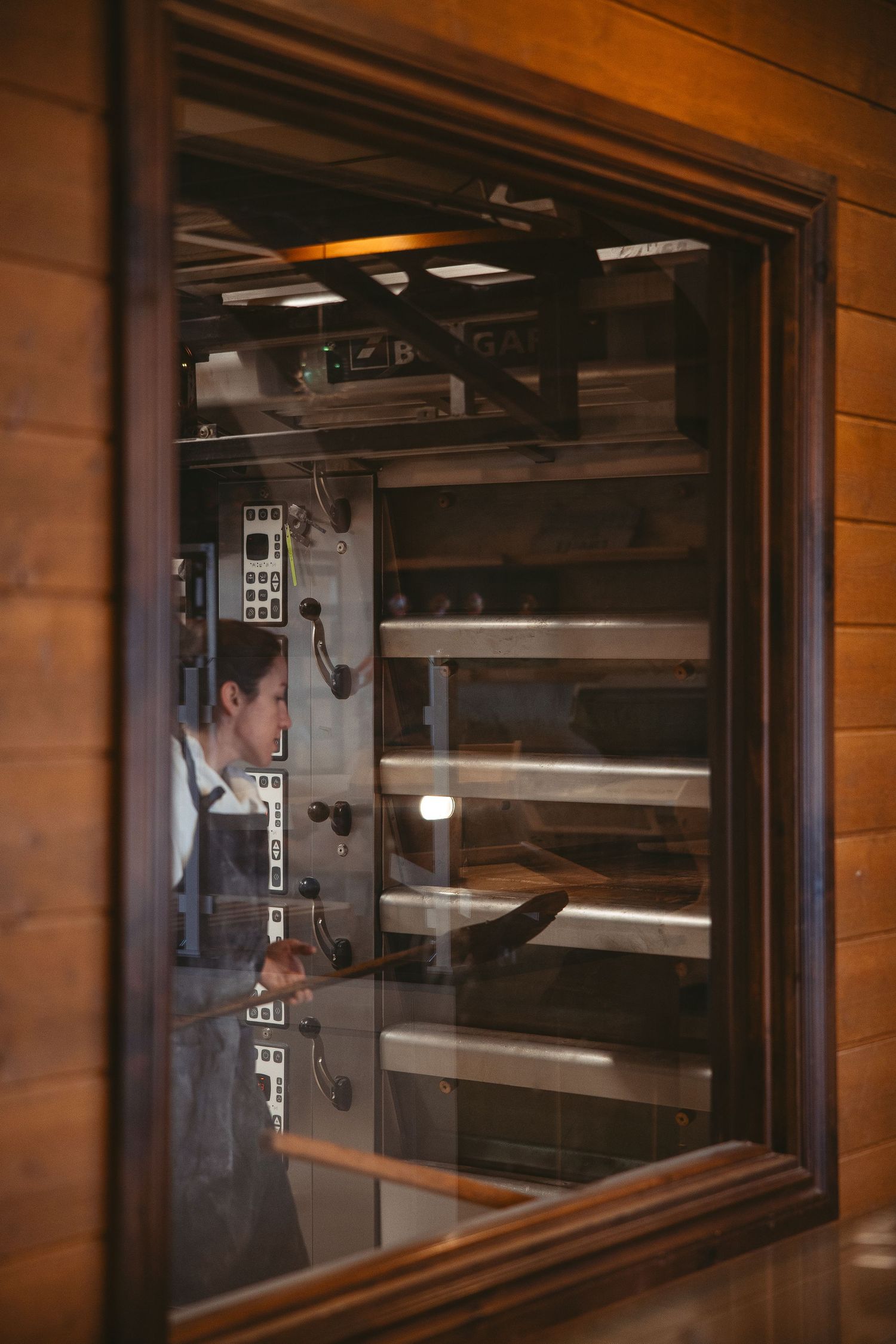 View through window of industrial bakery equipment and production area.