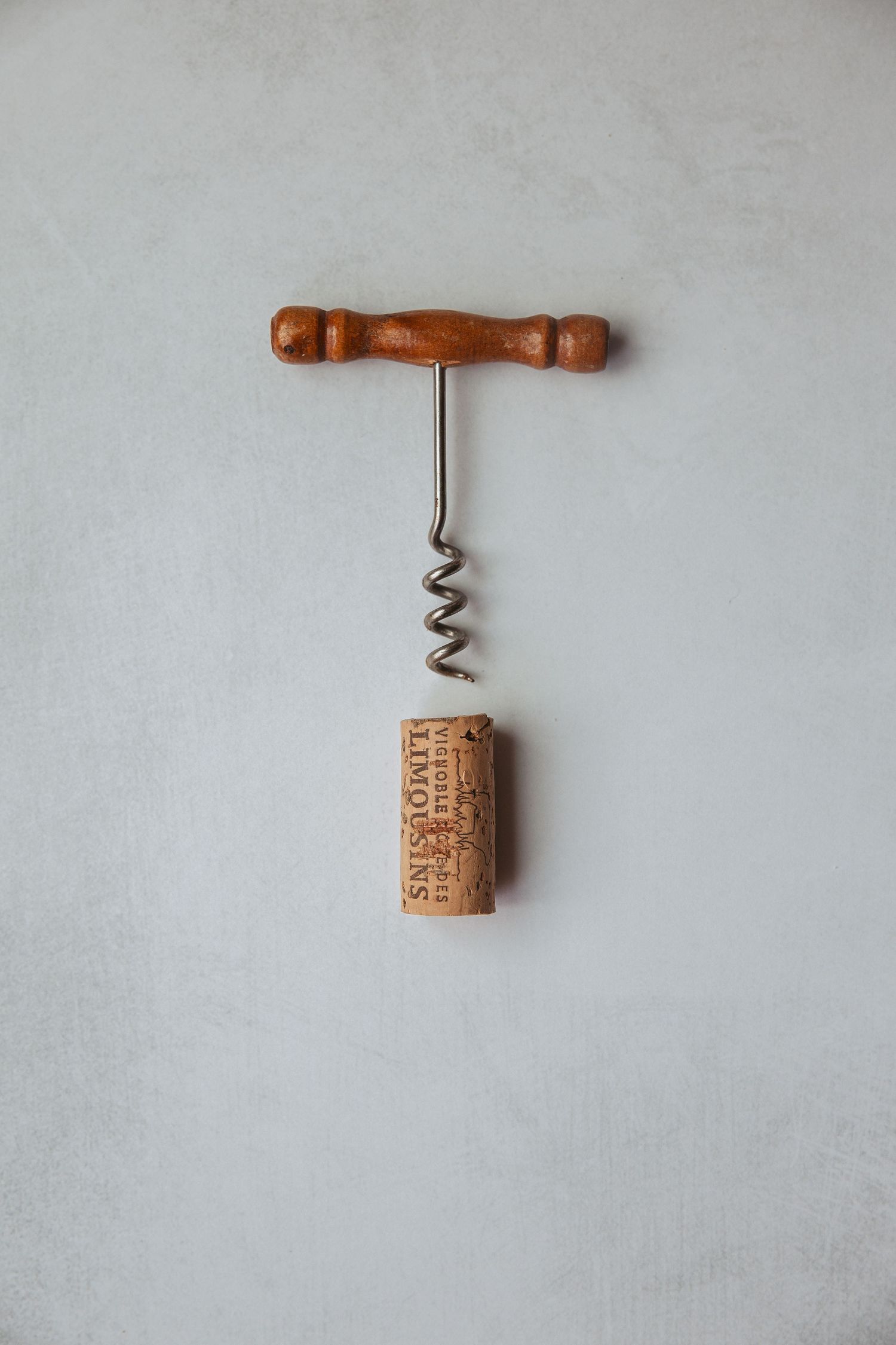 Vintage wooden wine cork openers displayed on a light gray background.