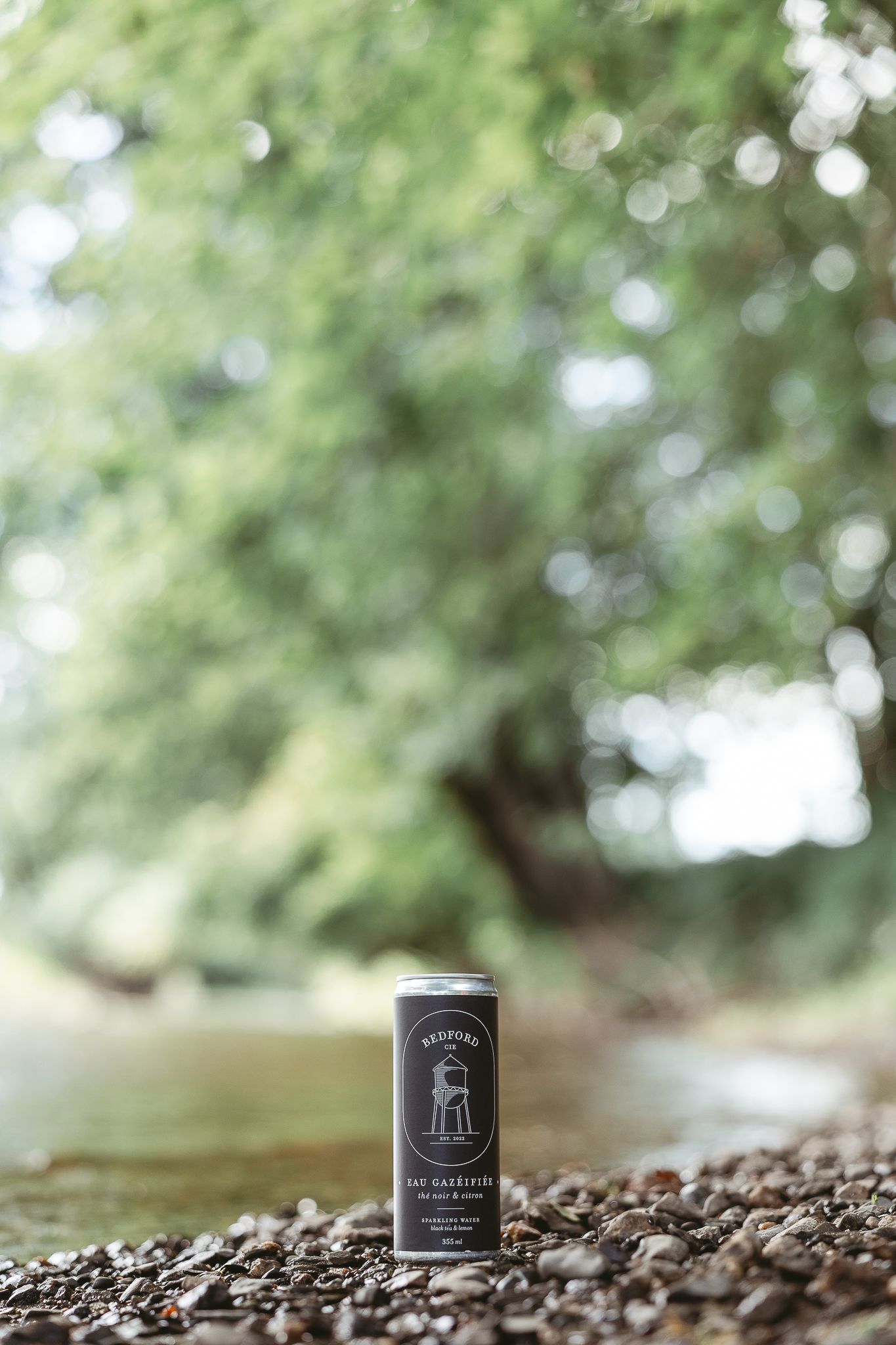 Photographie entreprise Canette eau pétillante Bedford cie saveur thé noir et citron sur le bord d'une rivière en fôret en Estrie
