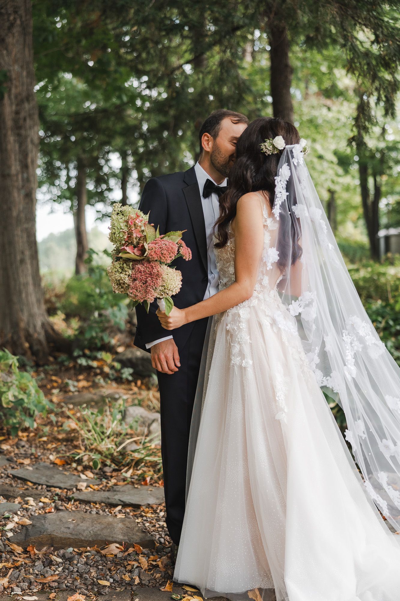 Moment de first look romantique entre la mariée et le marié dans un décor boisé aux feuilles d’automne