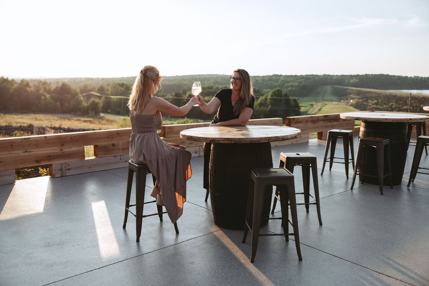 Outdoor terrace seating area with tables and chairs overlooking a scenic landscape view.
