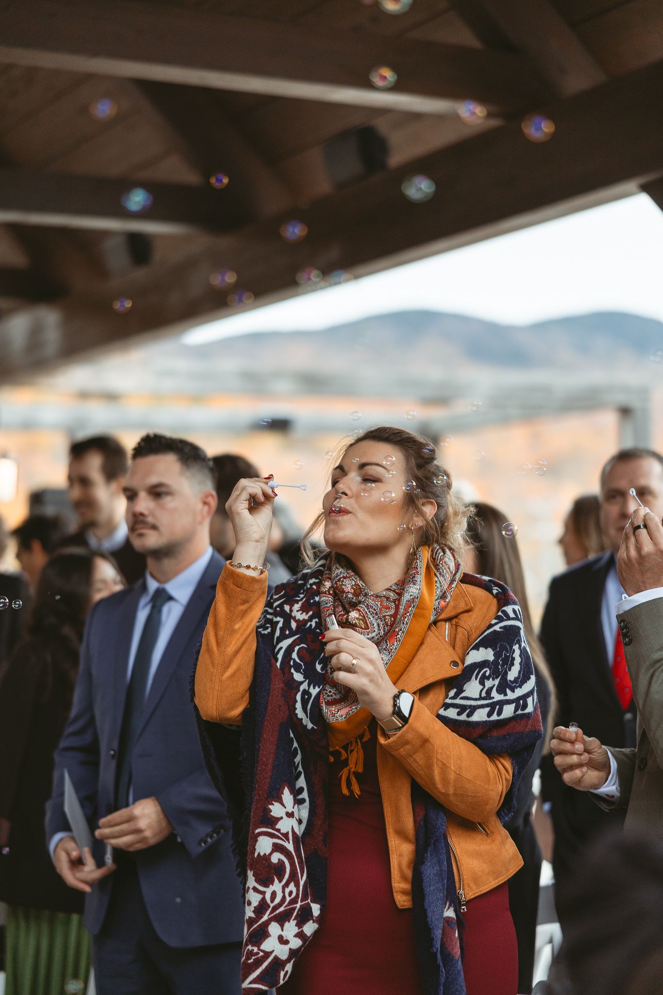 Invités qui soufflent des bulles pour l'ambiance quand les mariés célèbre leur union dans un décor automnale