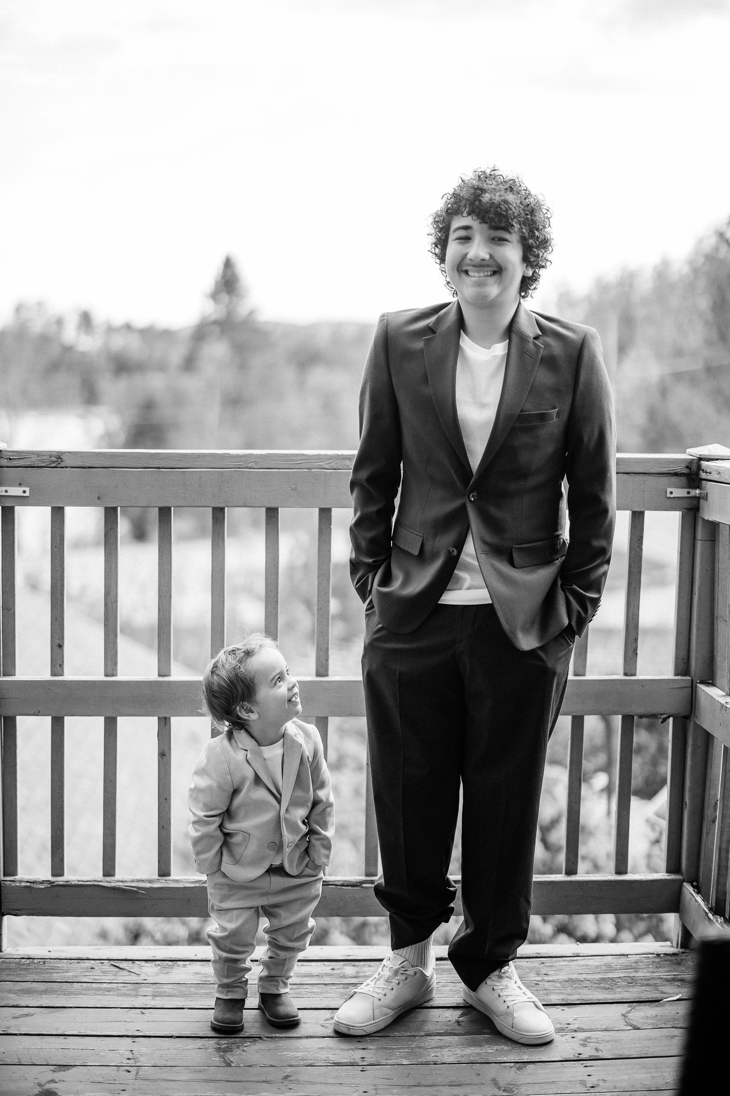 Séquence de photos de mariage en noir et blanc montrant un adulte et un jeune enfant sur un balcon en bois en extérieur.