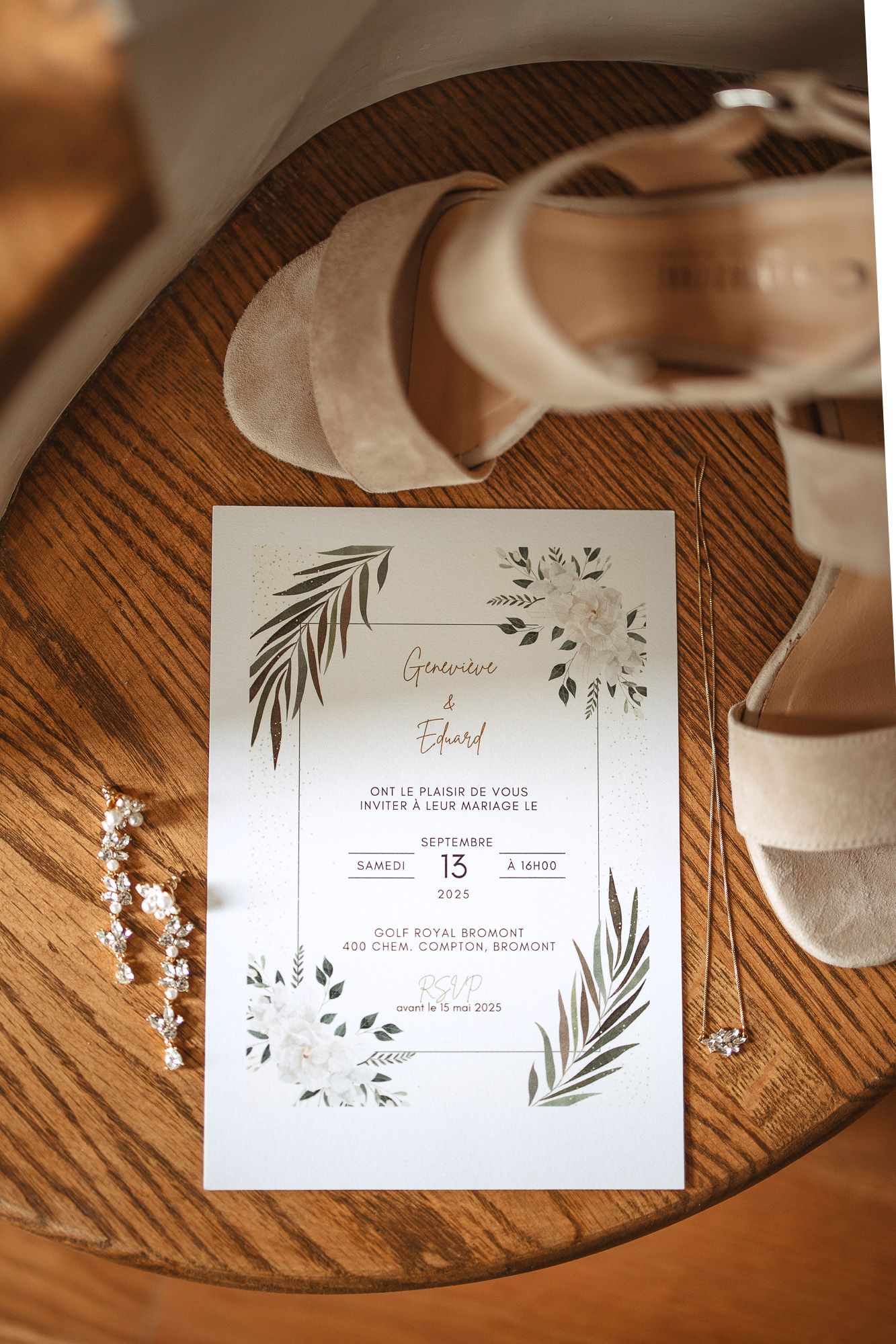 Faire-part de mariage avec motif floral et feuilles de palmier, ruban blanc, posé sur une surface en bois