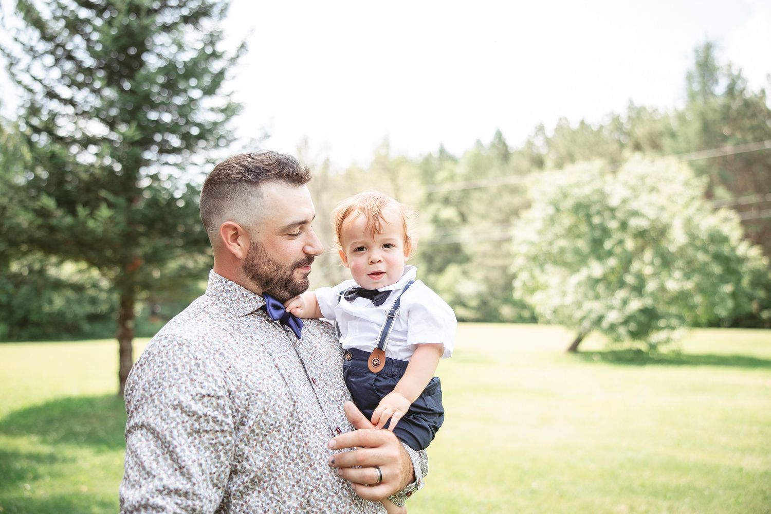 Parent et jeune enfant partageant des moments tendres en extérieur, dans un décor naturel