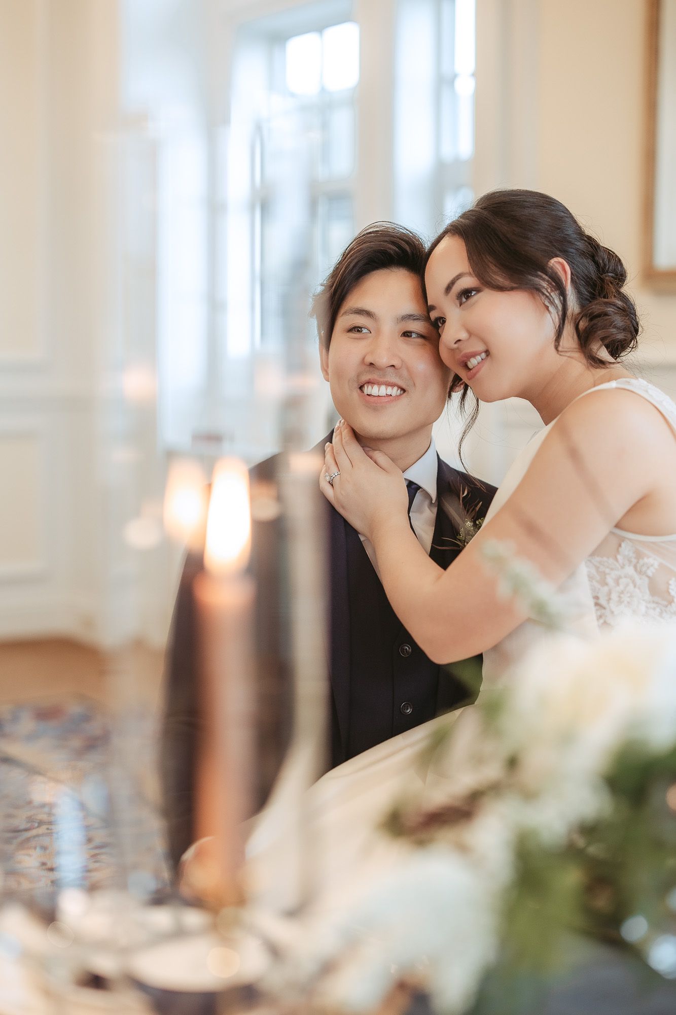 Moment romantique de réception de mariage capté à une table élégante, avec éclairage doux et décor floral
