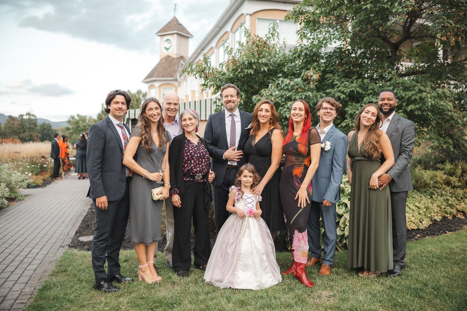 Photos de groupe du cortège de mariage prises en extérieur, invités en tenue formelle