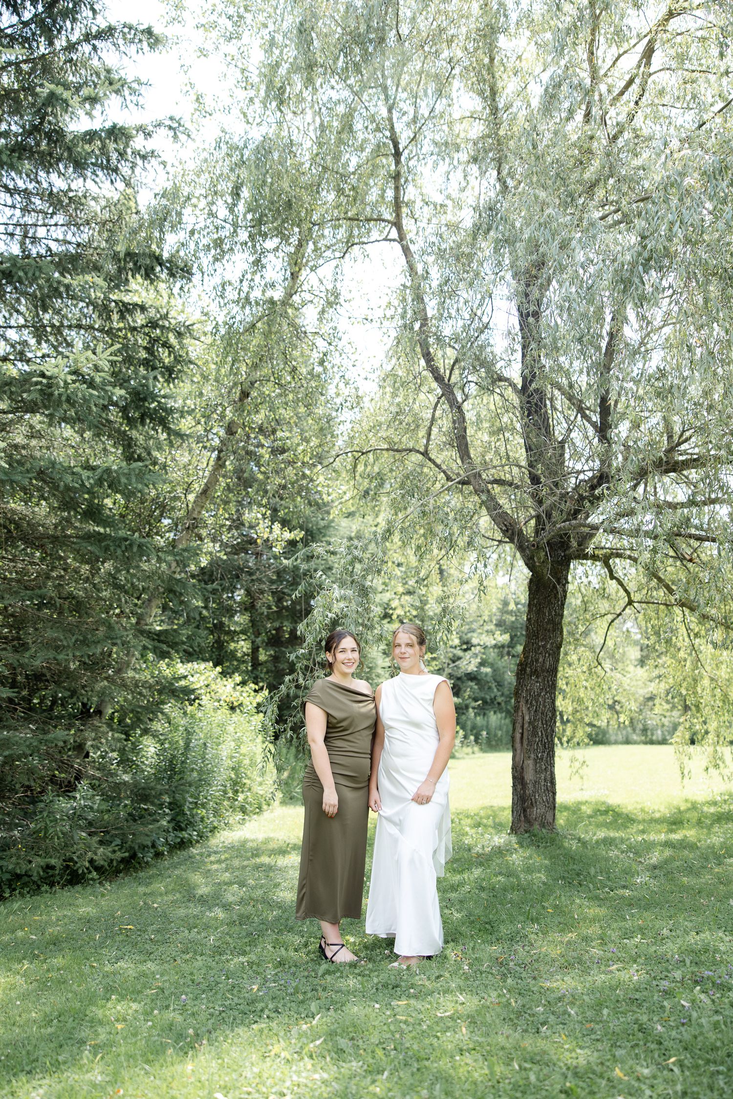 La mariée et sa fille d'honneur sous un saule par une journée ensolleillé