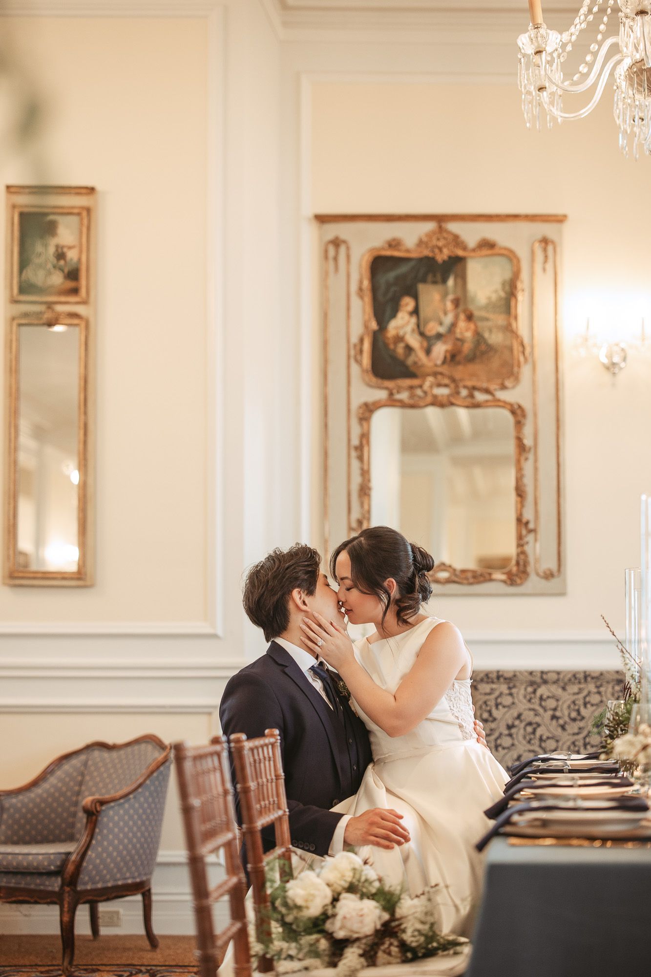 Mise en place de table de mariage élégante avec guirlandes de verdure, bougies et vaisselle, en lumière naturelle douce