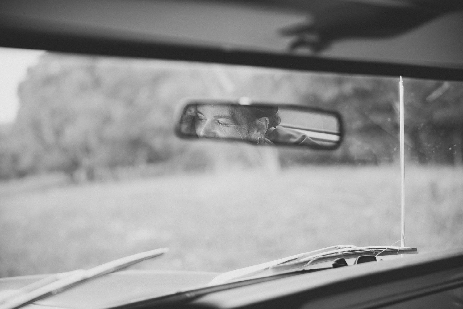 Photo vintage en noir et blanc d’une Ford avec mariés dans rétroviseur