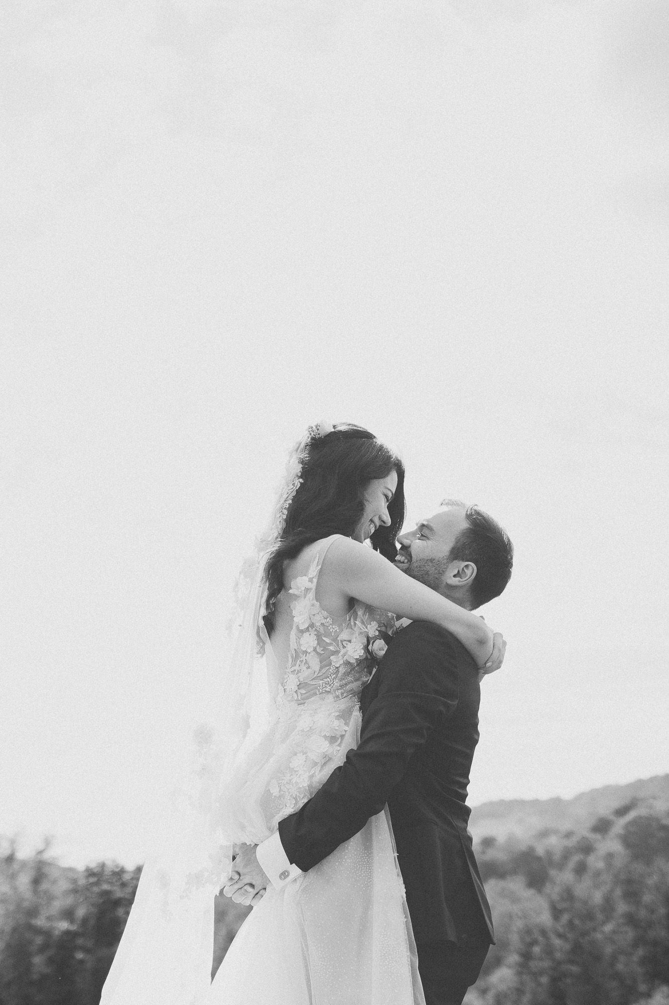 Portrait romantique en noir et blanc d’un couple de mariés s’enlaçant en extérieur, mariage en Estrie