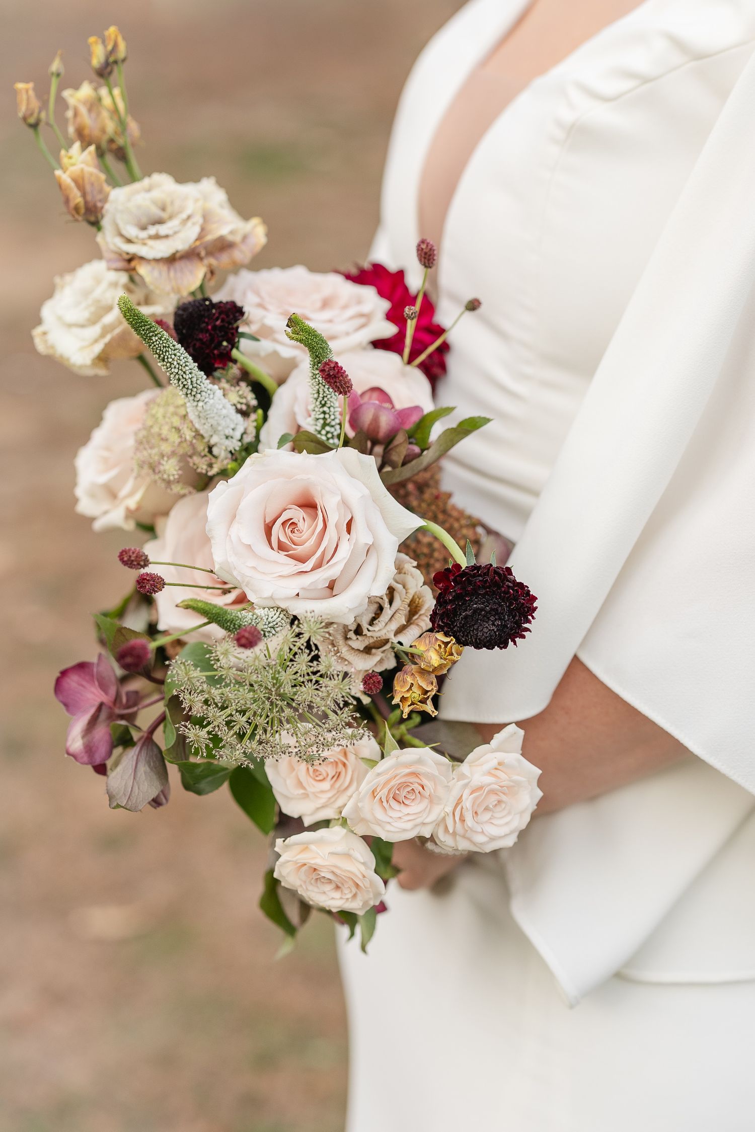 Plan rapproché de la mariée qui tient son bouquet de fleur en autonme