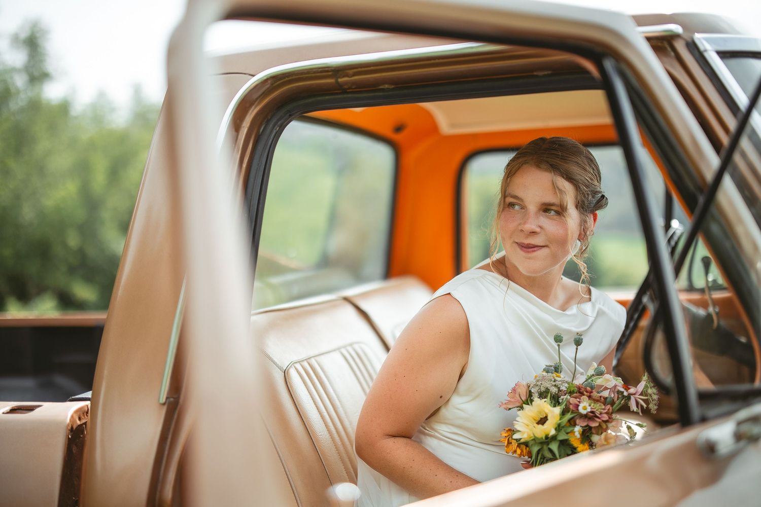 photos de mariage montrant l’intérieur d’une voiture classique avec bouquets de tournesols et détails élégants
