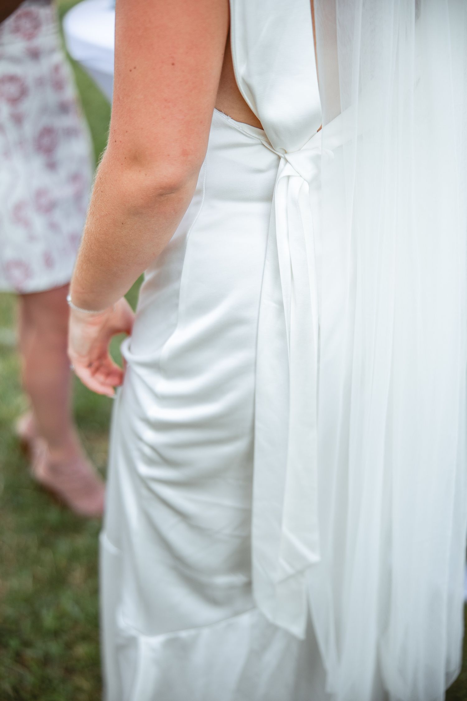 Gros plan sur les détails d’une robe de mariée blanche, drapé délicat et plis fins, photographié lors d’un mariage en Estrie