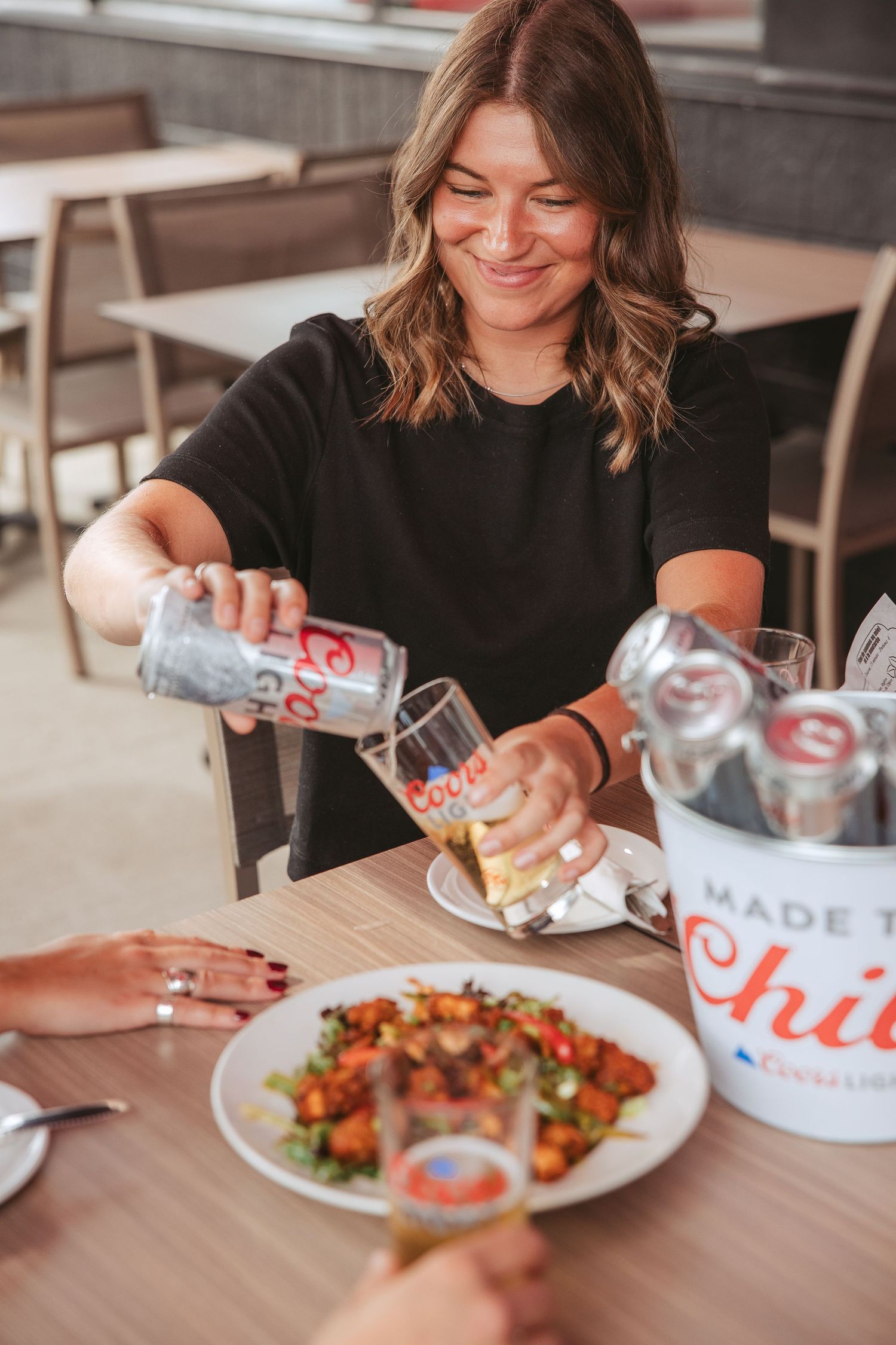 A series of photos showing someone dining at a restaurant table with Chick-fil-A beverages and food plates.