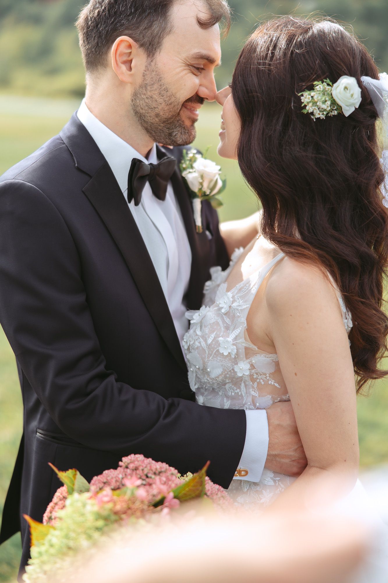 Moment romantique de mariage en extérieur avec un couple en tenue élégante, détails floraux délicats et lumière douce, en Estrie