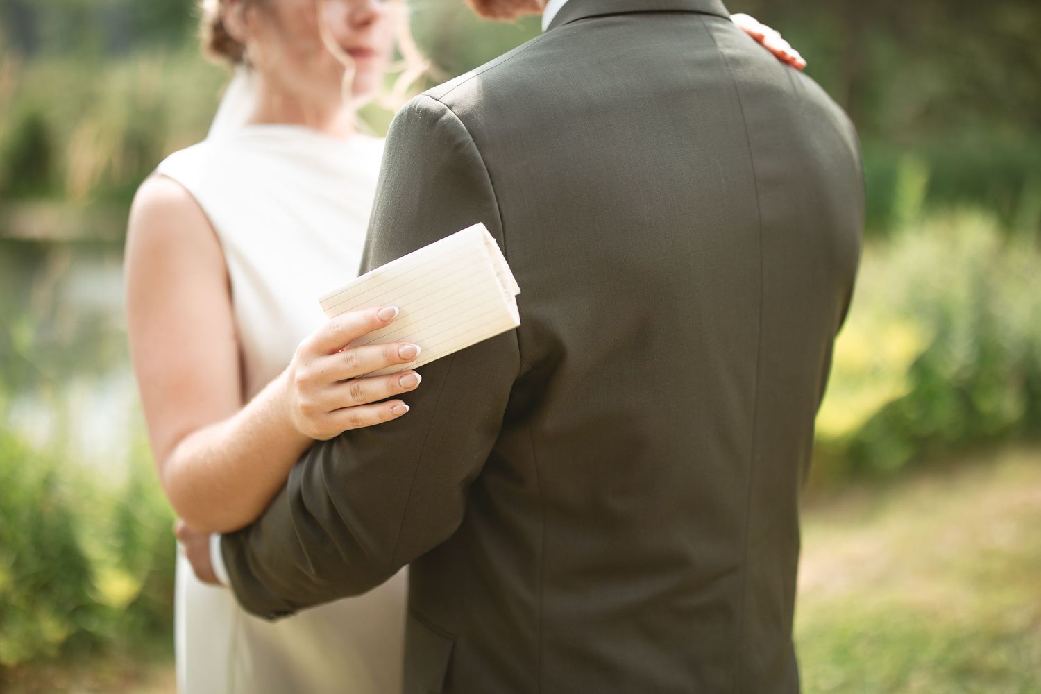 Couple de mariés lisant leurs voeux intime ensemble lors d’une cérémonie de mariage en plein air, à la lumière naturelle