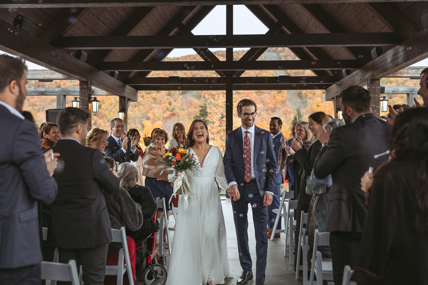 Les mariés après leurs cérémonie défile l'allée encouragé par leurs amis et familles dans un décor automnale