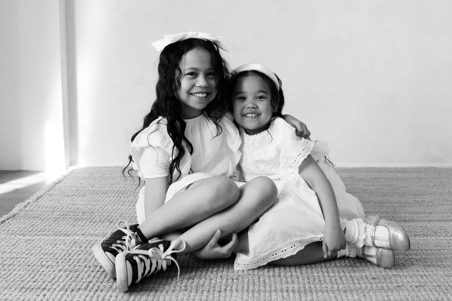 Black and white portrait series showing relaxed poses on floor.