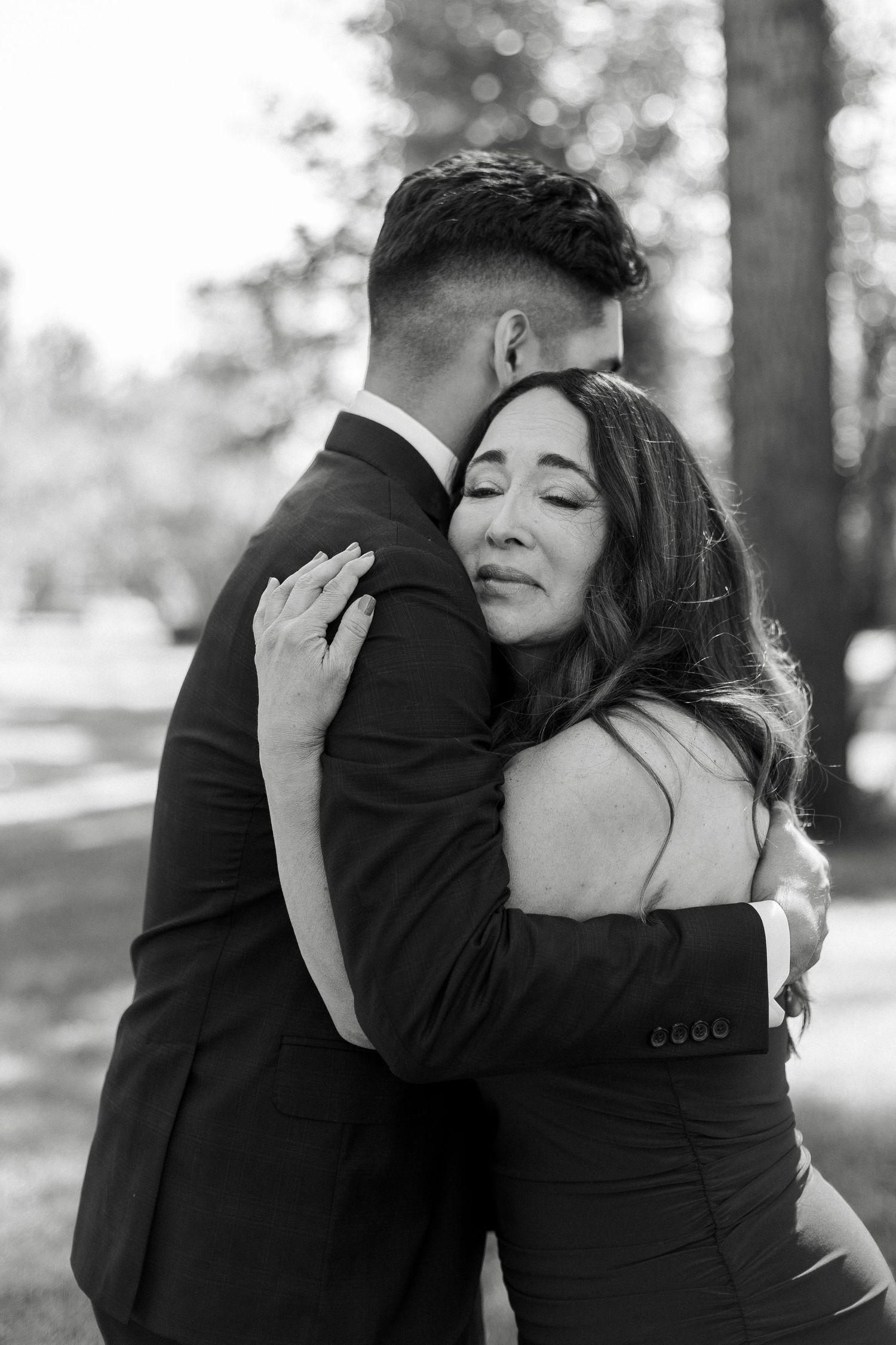 A couple embraces in a romantic outdoor photo series showing multiple tender moments in black and white.