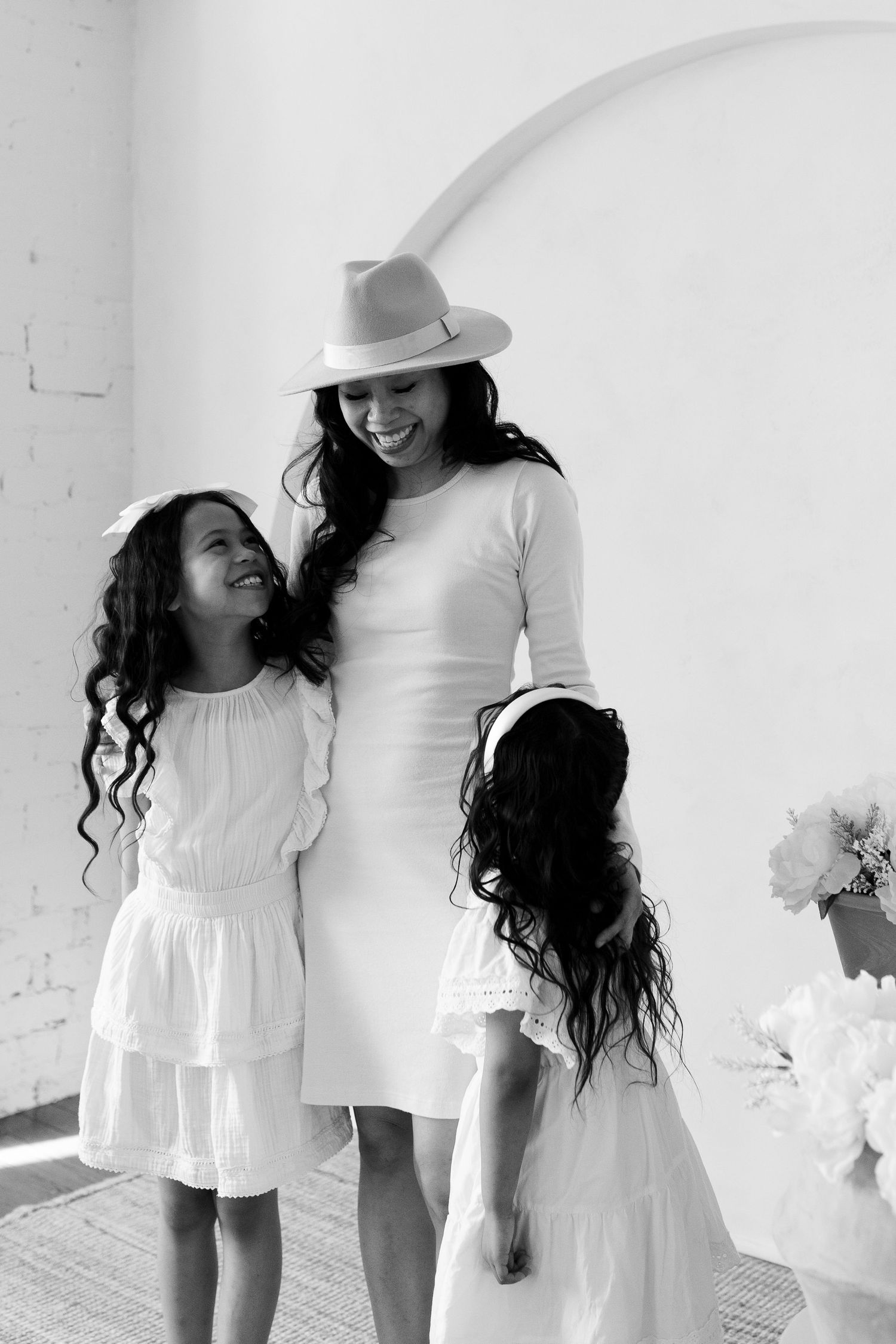 Series of intimate family moments captured in white against minimalist backdrop.
