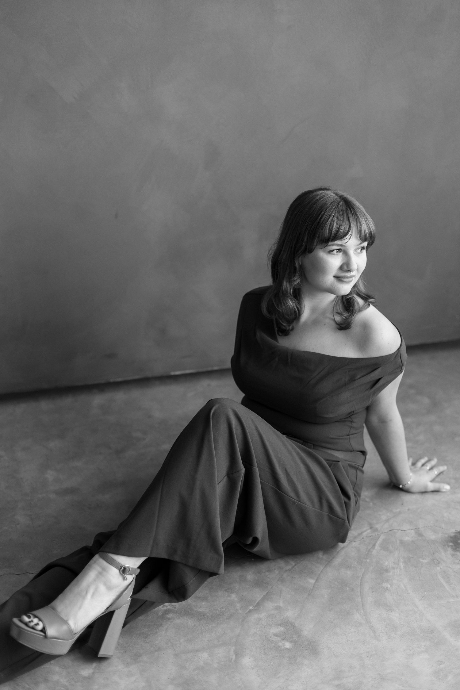 A black and white photo sequence shows a figure in a dark dress reclining on the floor in different poses.