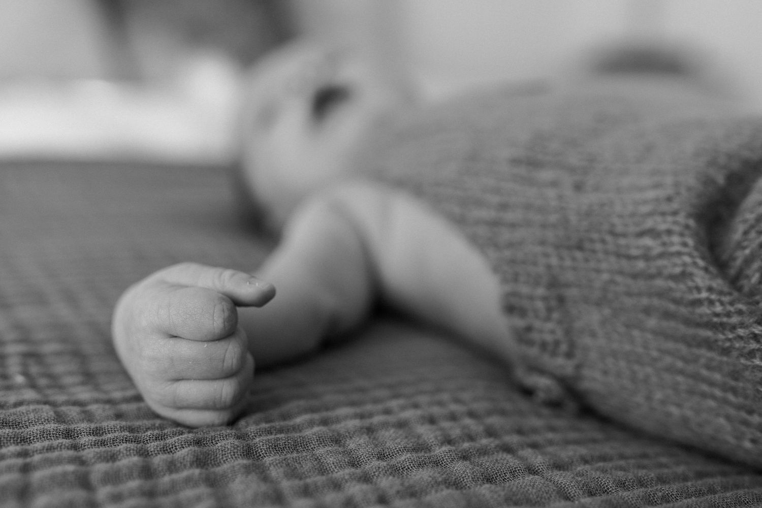 Close-up sequence of hands gently touching and exploring textured gray fabric material.