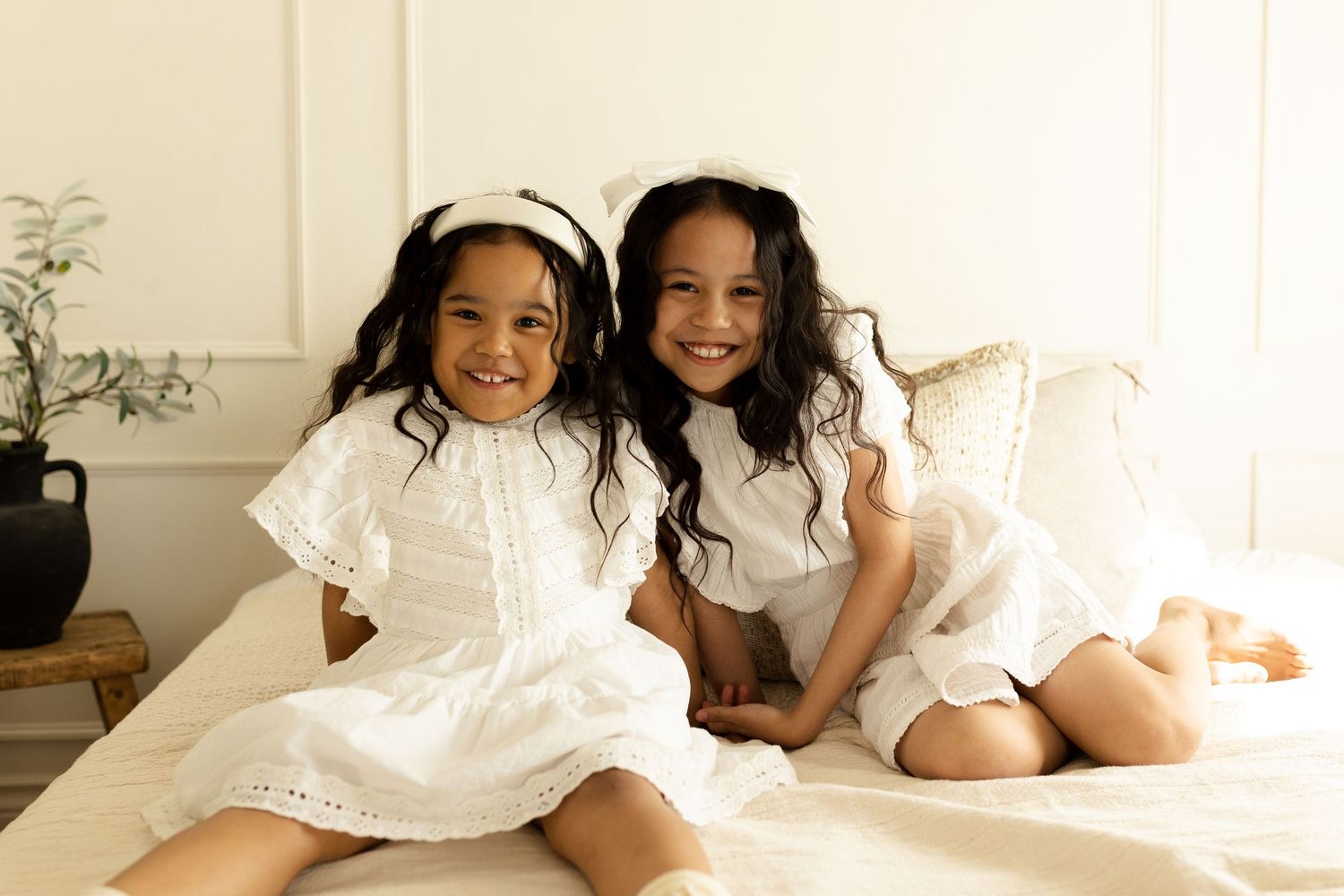 Family portrait series showing playful interactions on white bedding.