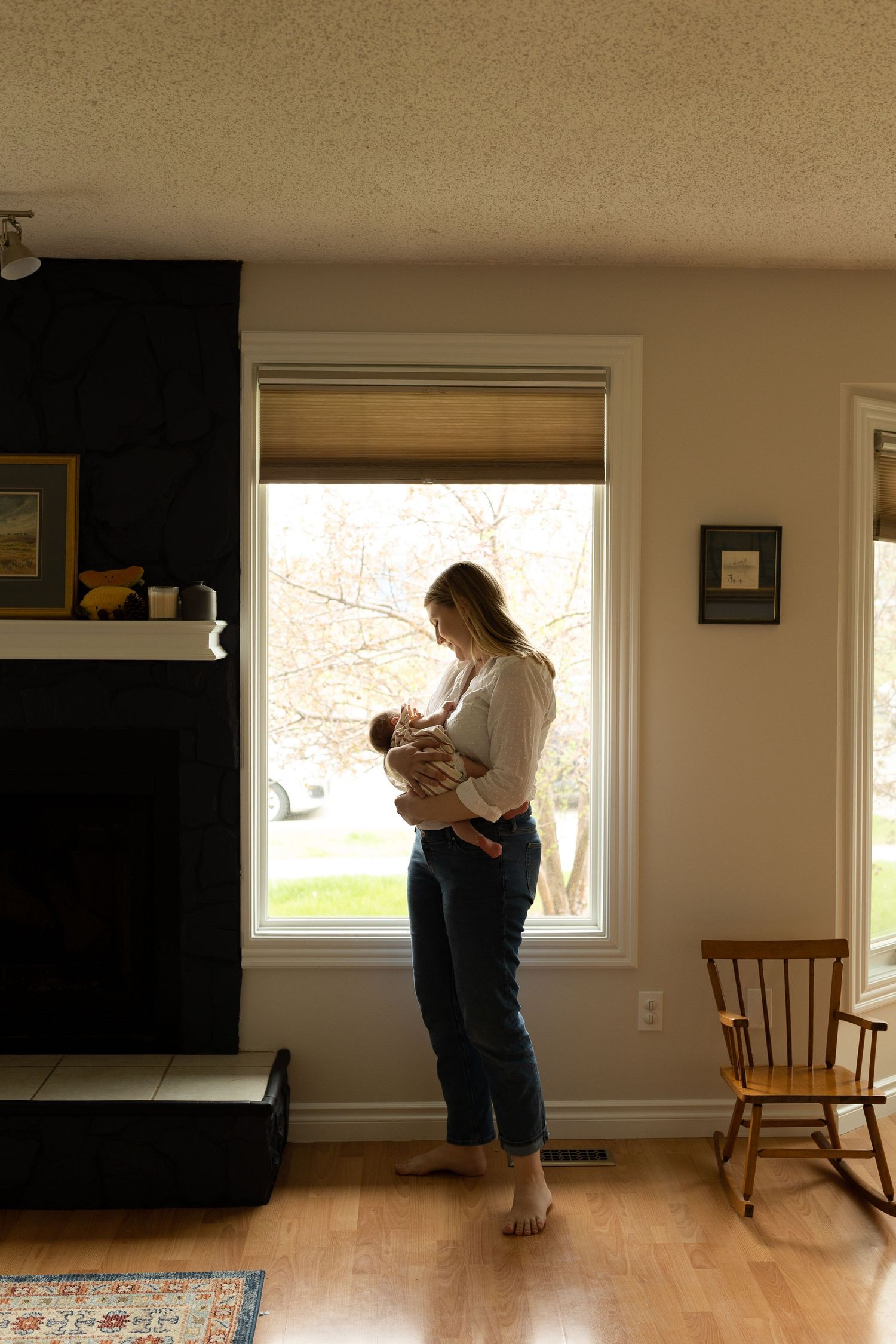 Intimate lifestyle newborn photography session in minimalist home setting.