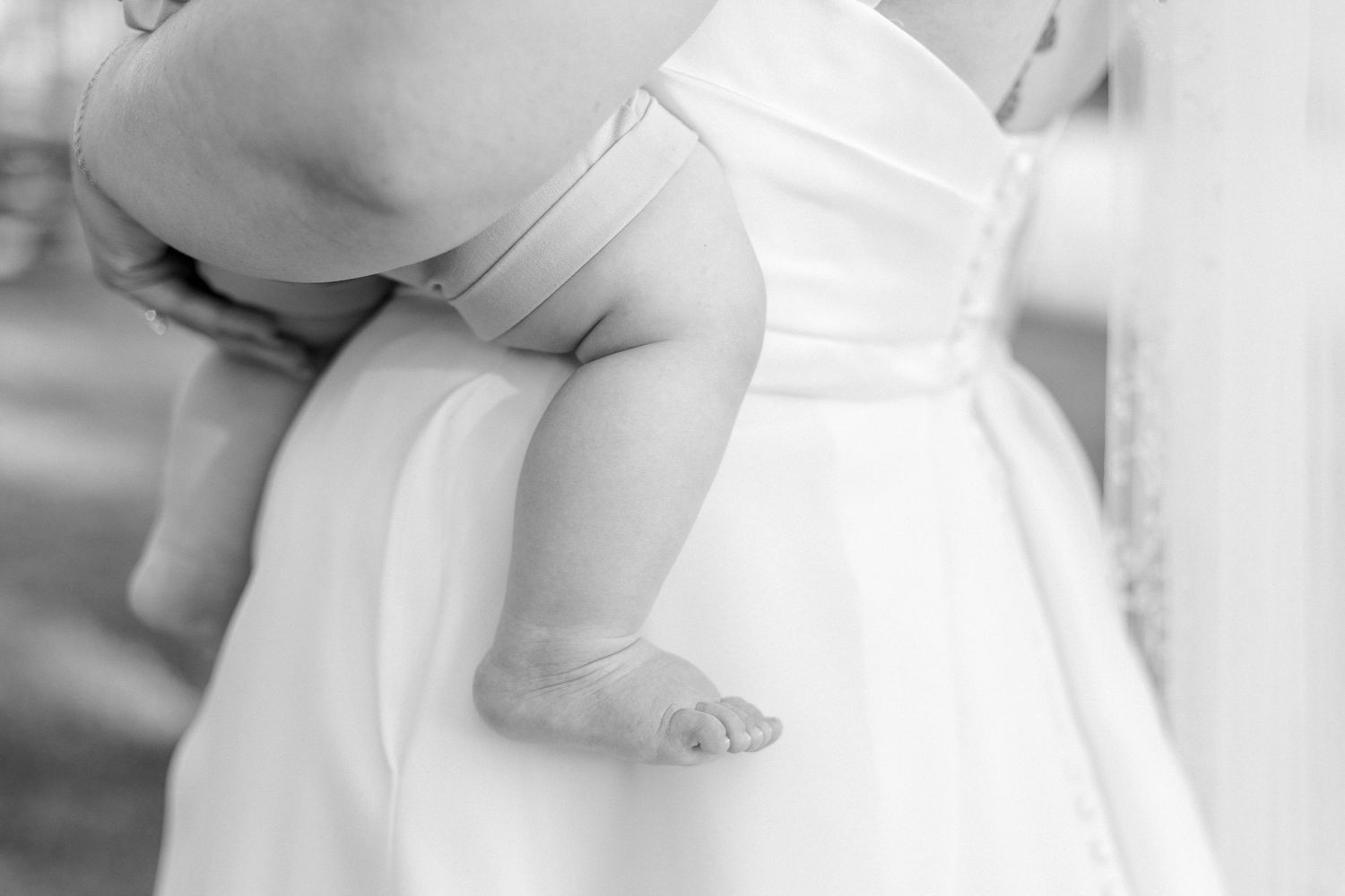 Close-up details of a white wedding dress with delicate lace and fabric textures.