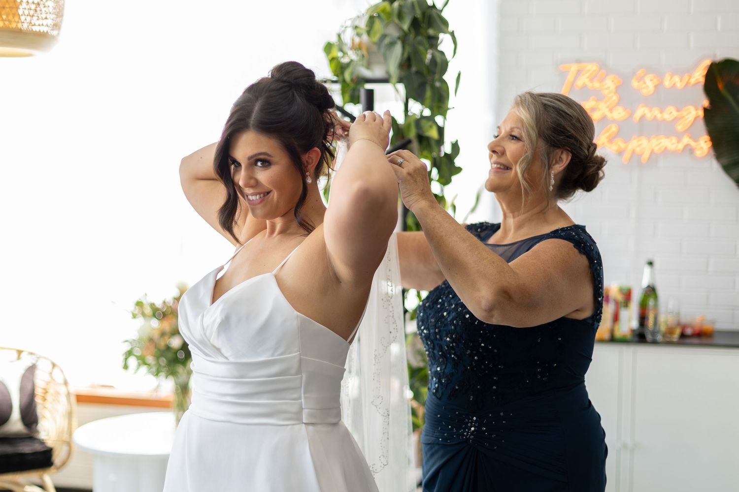 Wedding party members dance and celebrate during an indoor reception with warm lighting and decorative elements.