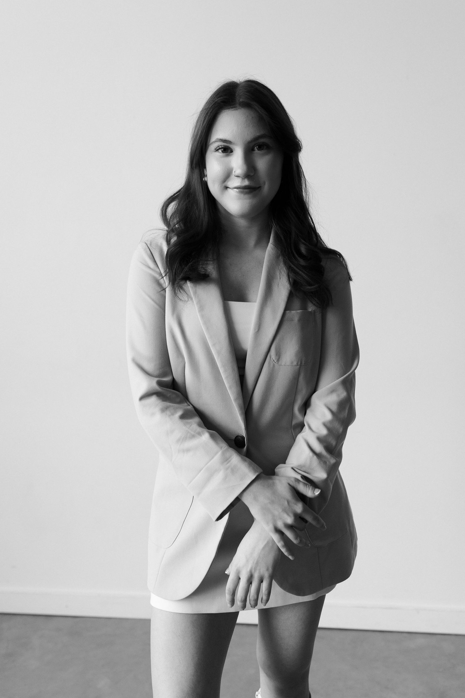 Professional headshots and poses in light grey blazer against neutral background.