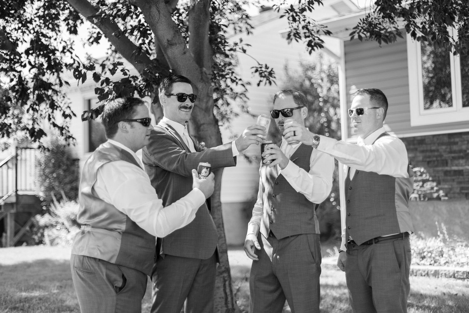 A black and white photo strip showing multiple candid moments at an outdoor wedding celebration.