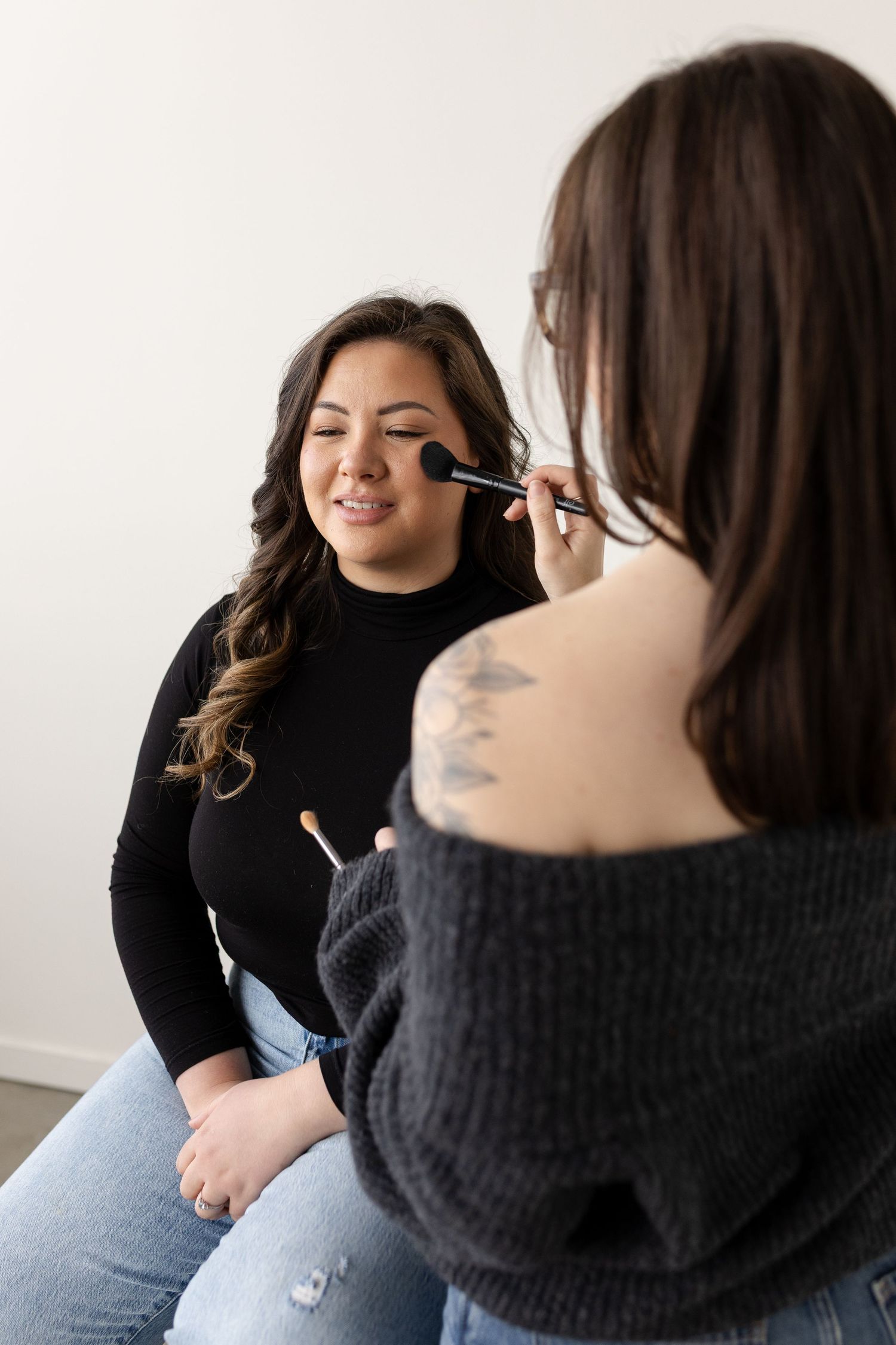 Series of poses showing a black turtleneck sweater and jeans ensemble against a white backdrop.
