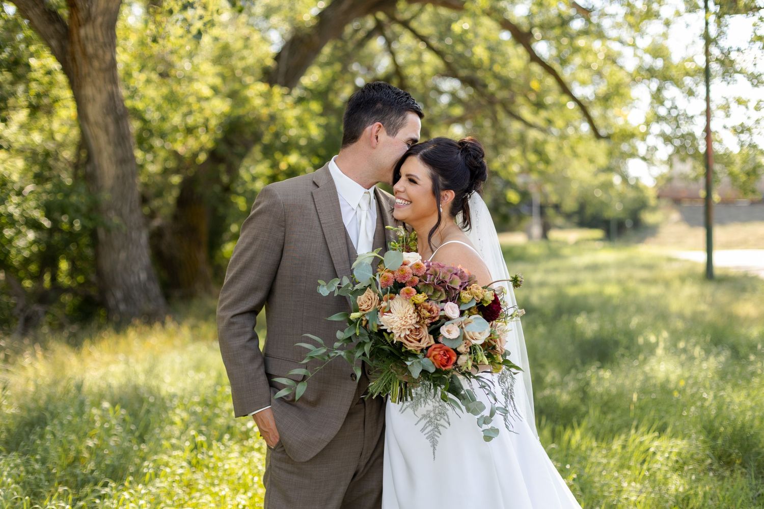 Elegant wedding portraits in golden sunlight with natural outdoor backdrop.