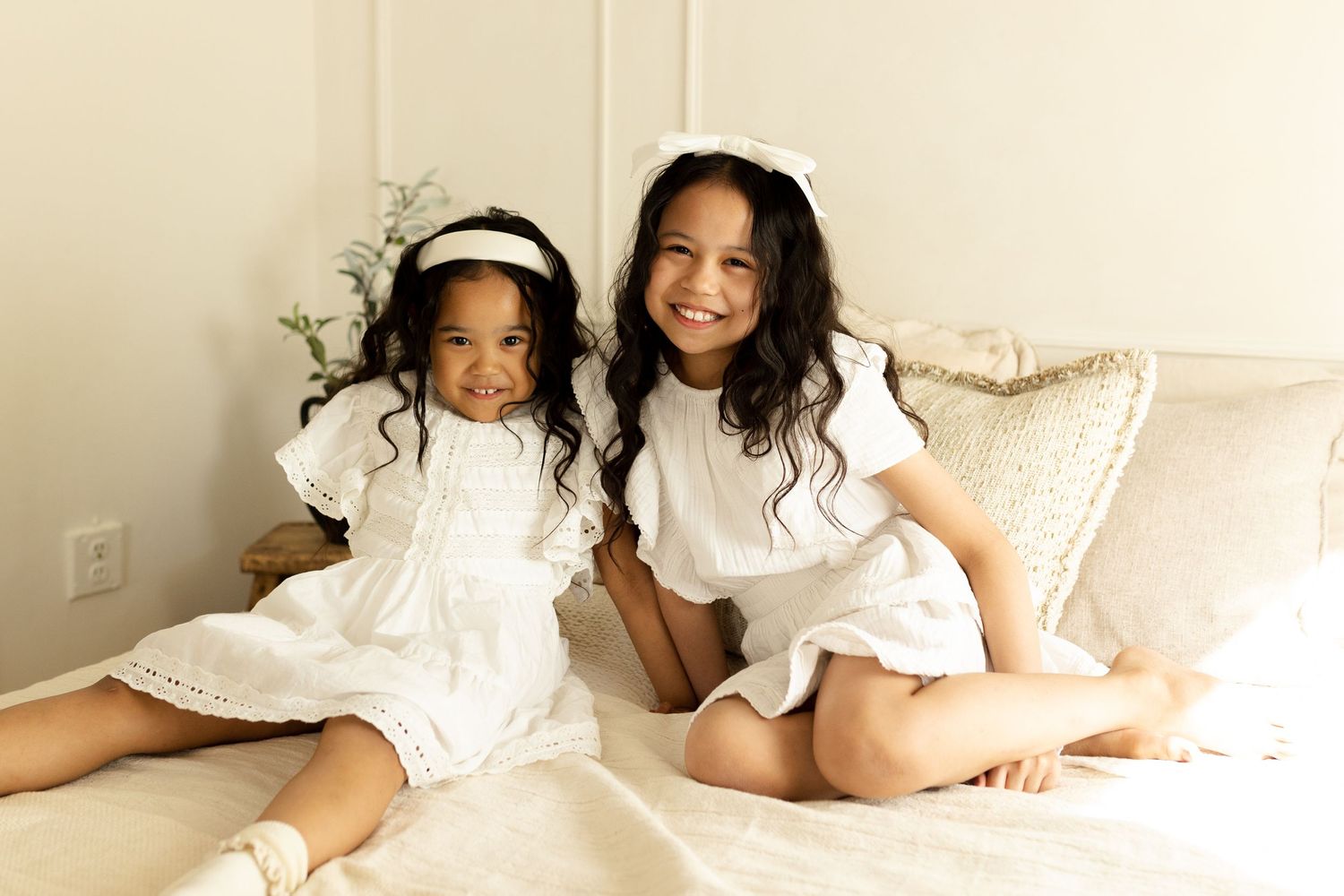 Intimate lifestyle portraits with subjects wearing white ruffled dresses in a bright, airy setting.