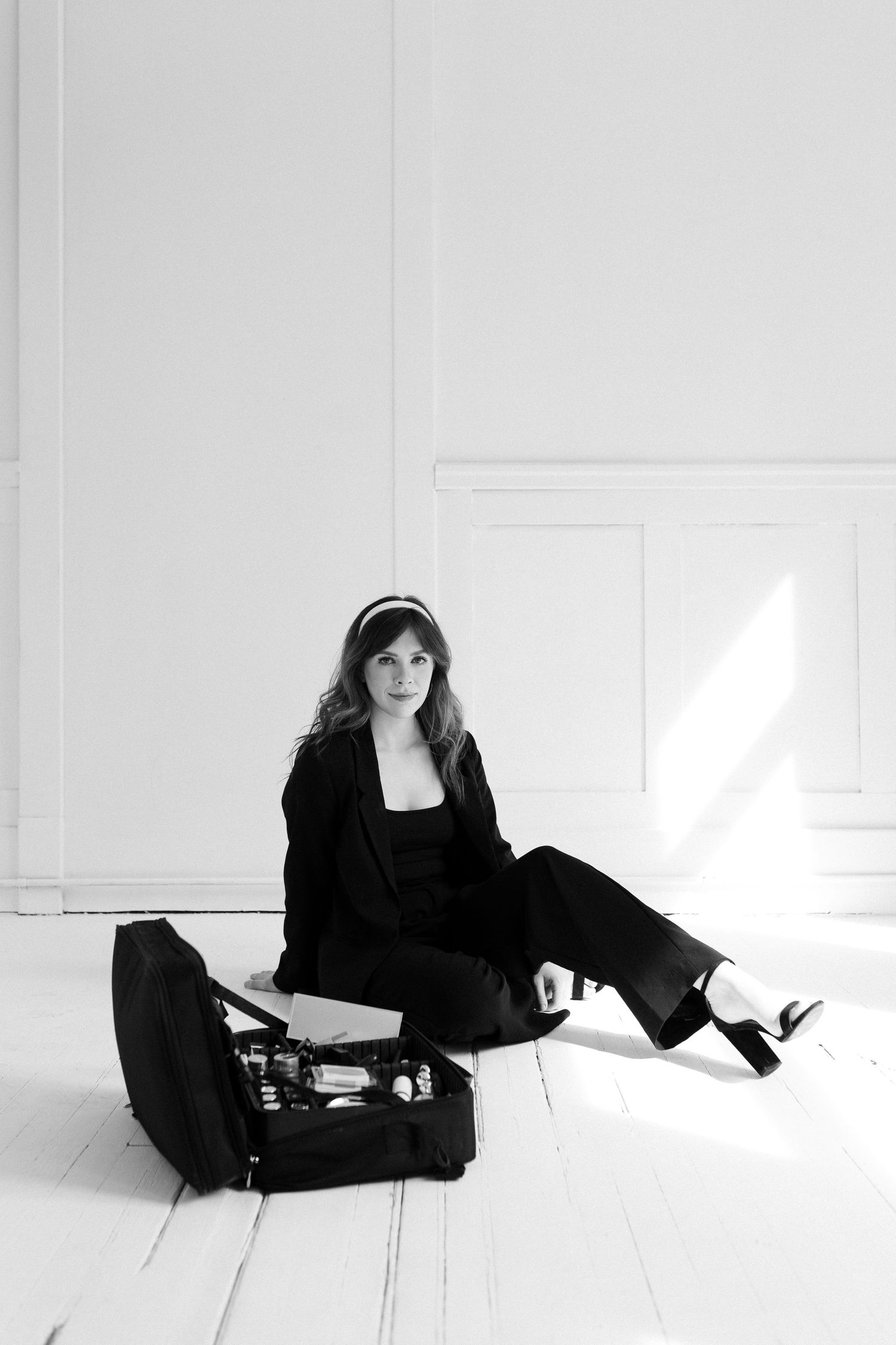 A person in black attire lying on a white floor in various relaxed poses.